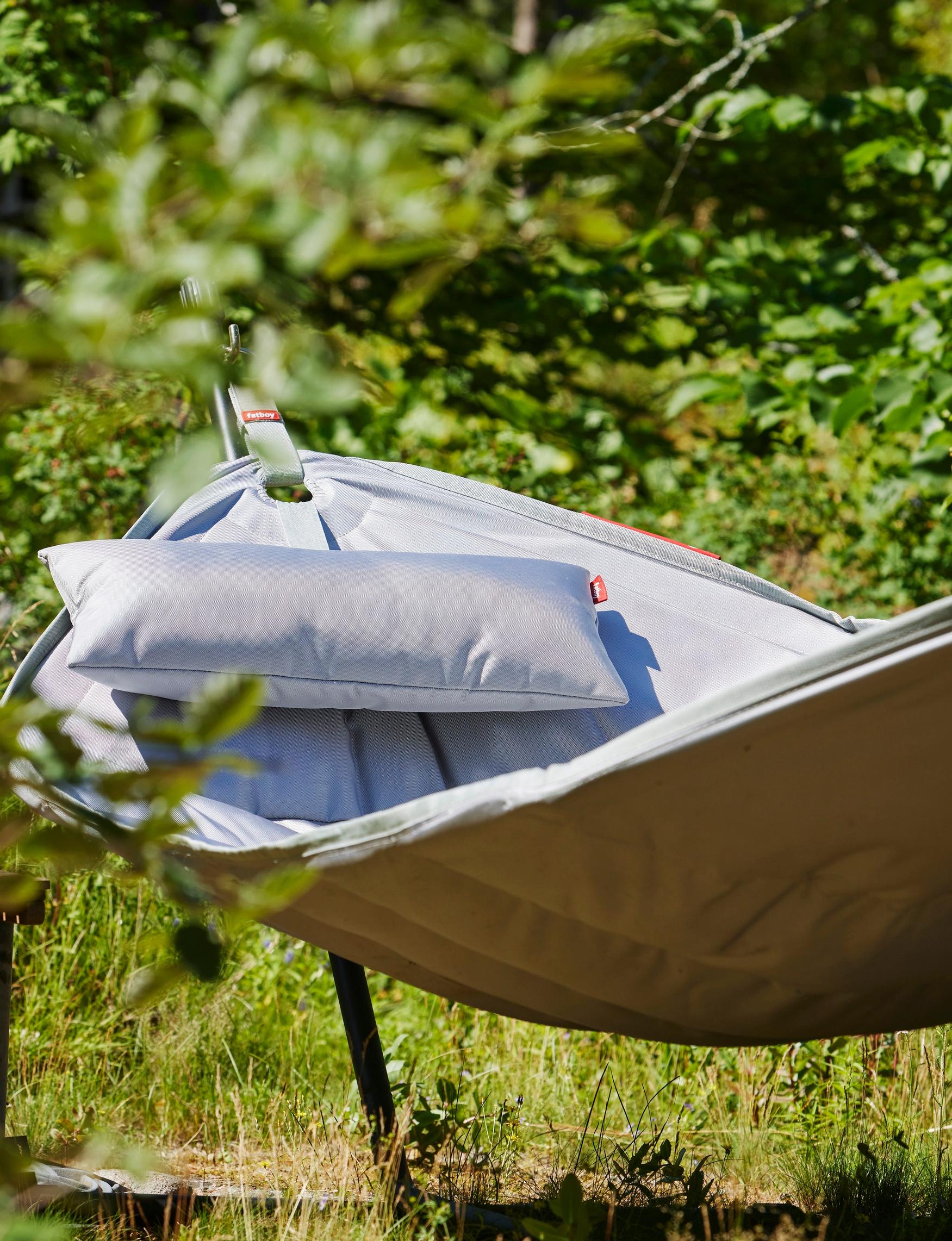 an empty Fatboy hammock with lush greenery behind