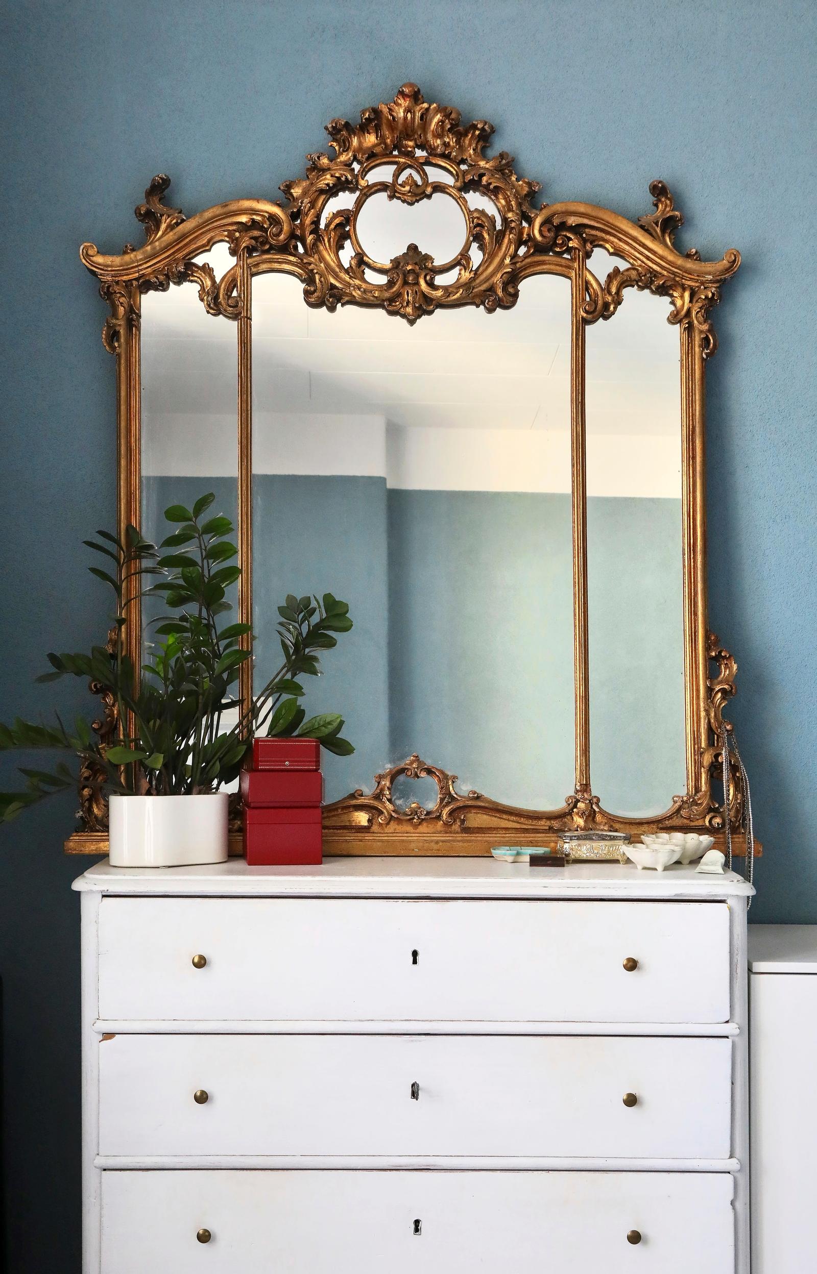 A large mirror on top of a chest of drawers