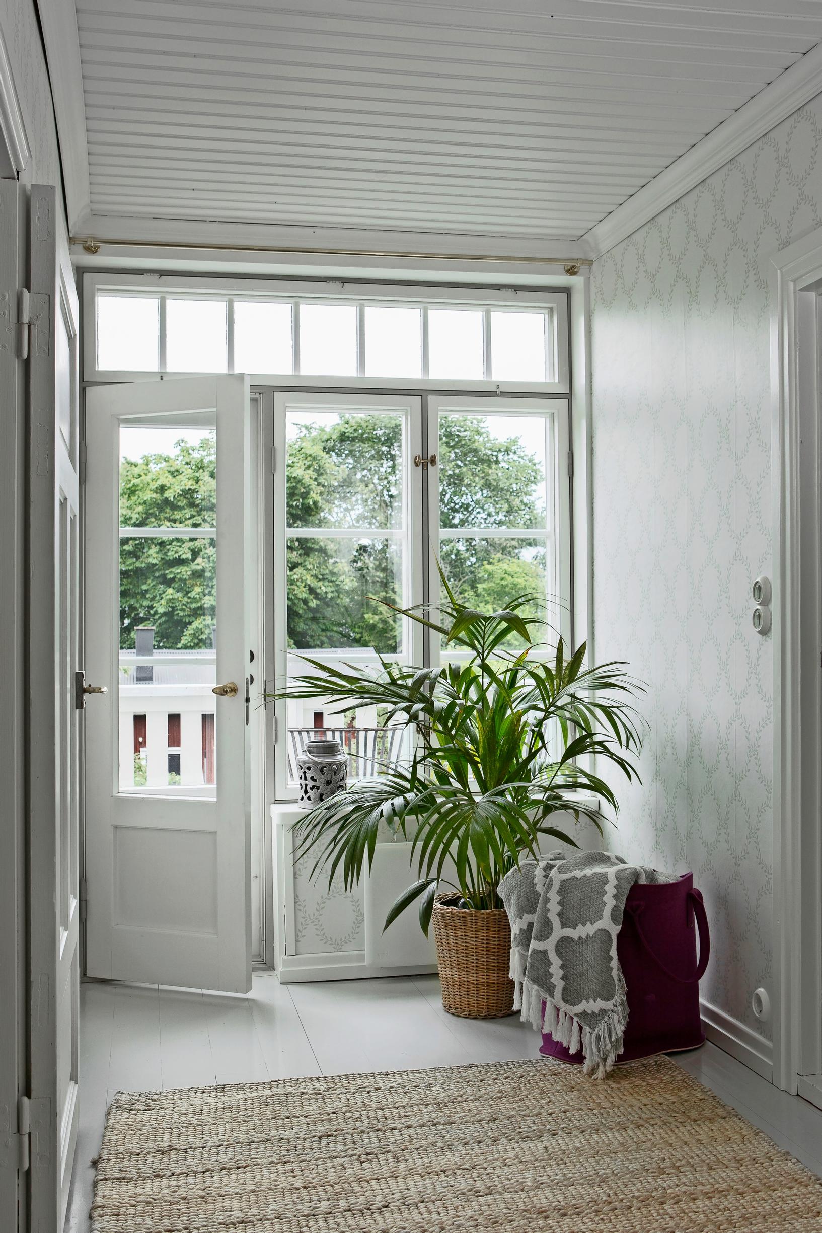 an upper hallway with a glass door and balcony