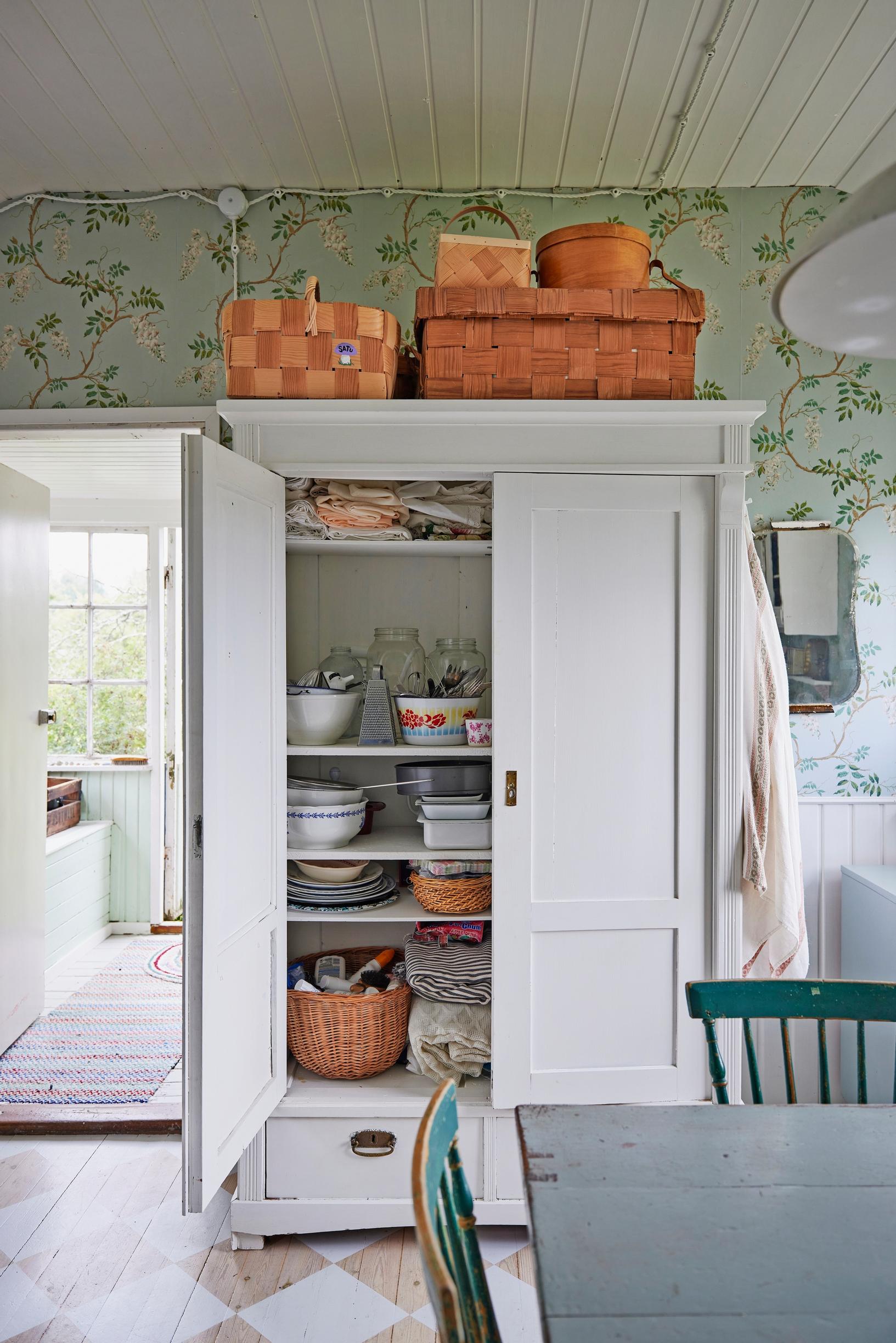an old white cabinet packed with dishes