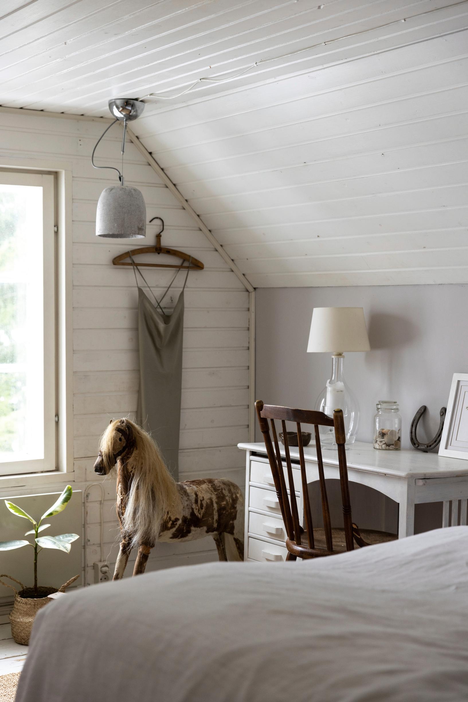 A children’s room with a rocking horse and a desk.