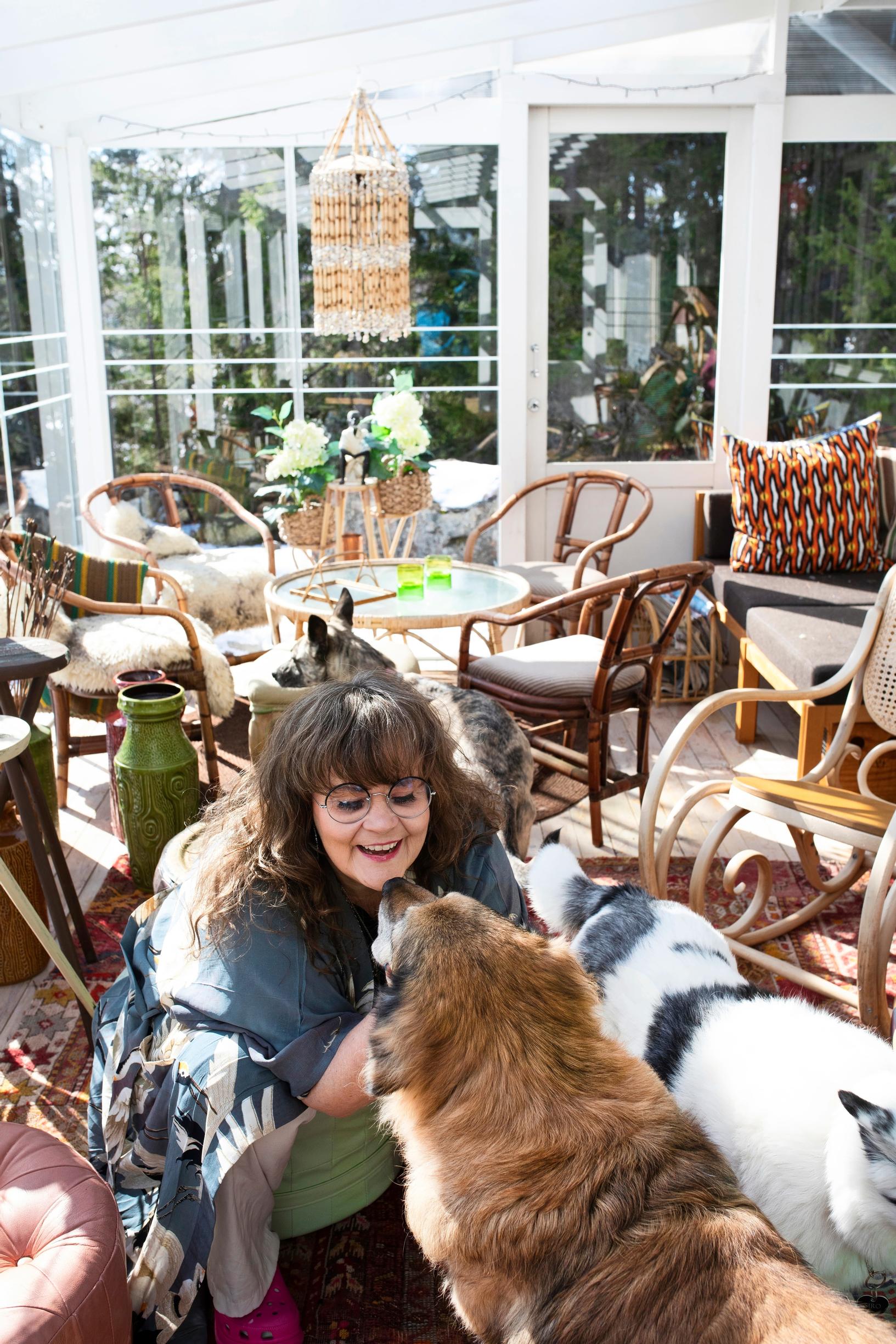 A woman petting a dog on a terrace