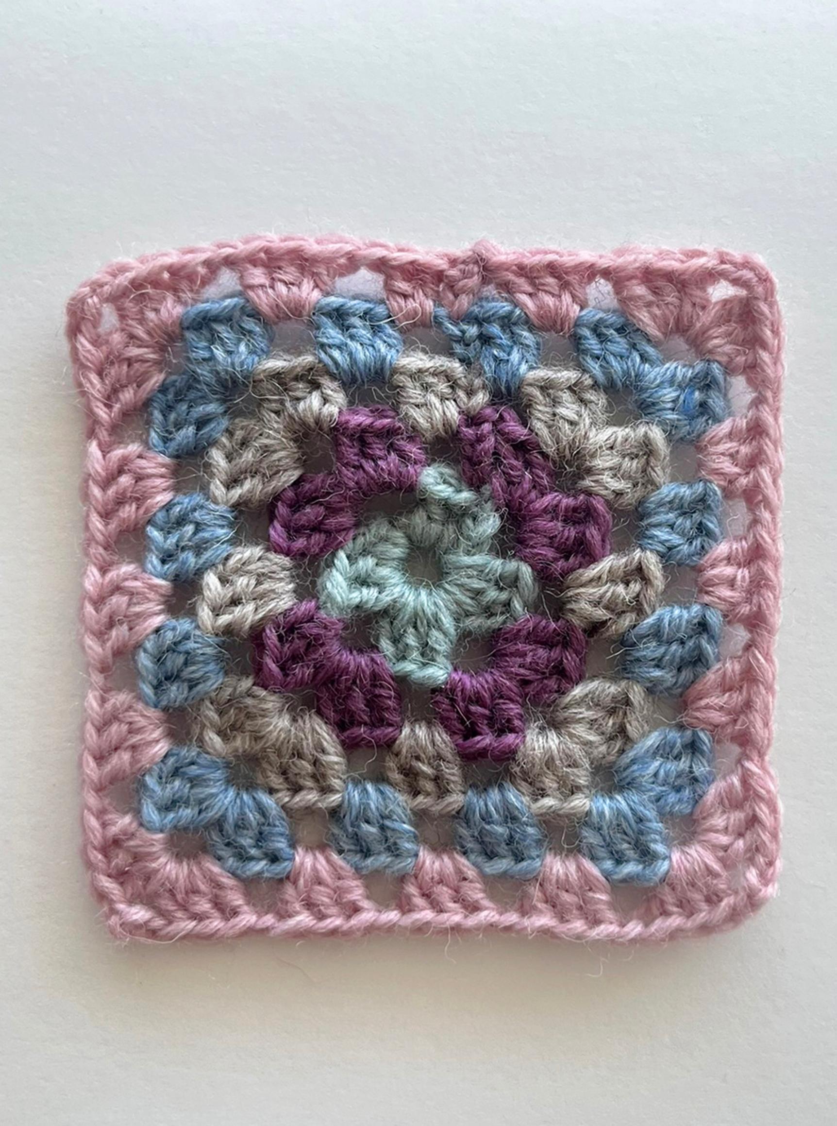 The fifth double-crochet round of the granny square is complete