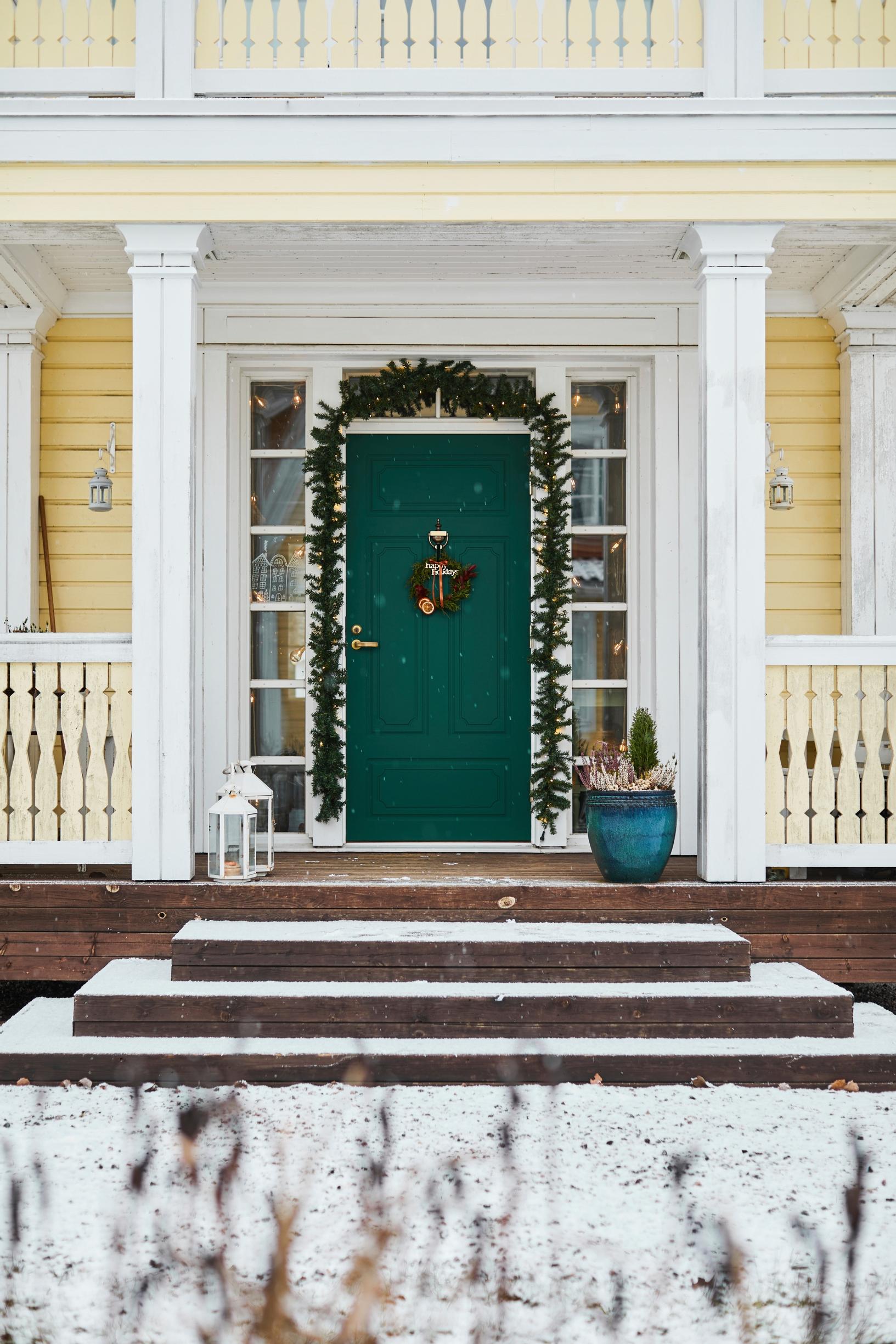 A green front door in a yellow house