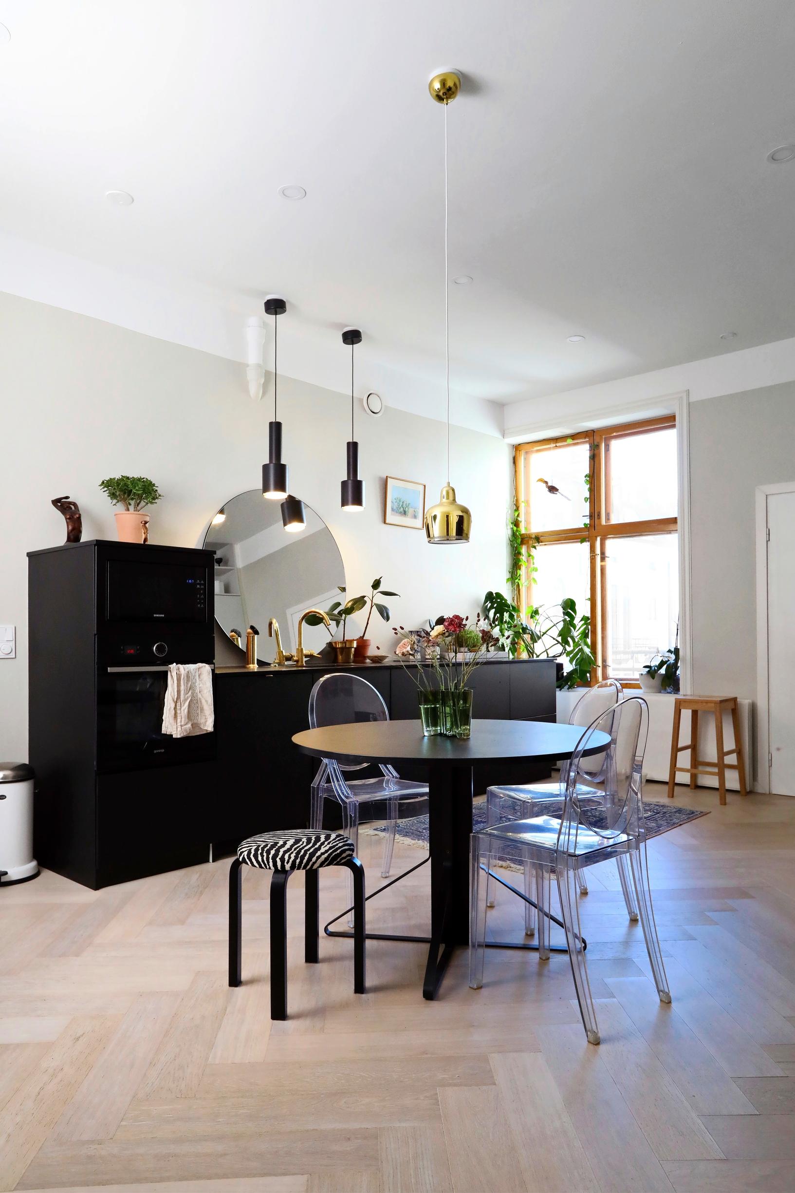 A black kitchen and a round dining table