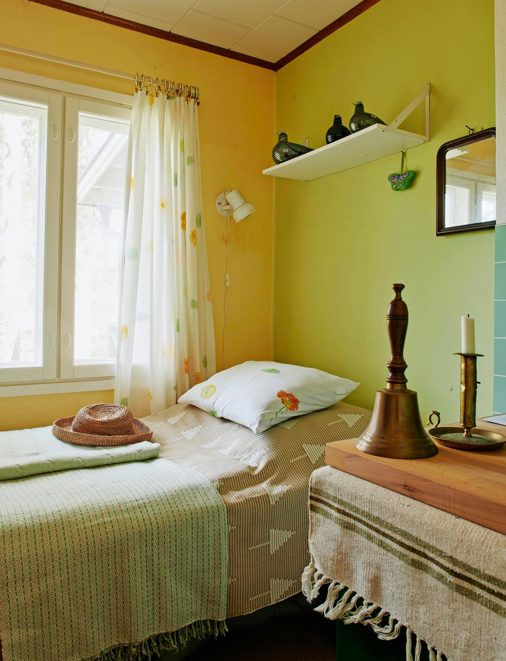 a hat on the bed, ornaments on the table and glass birds on the shelf