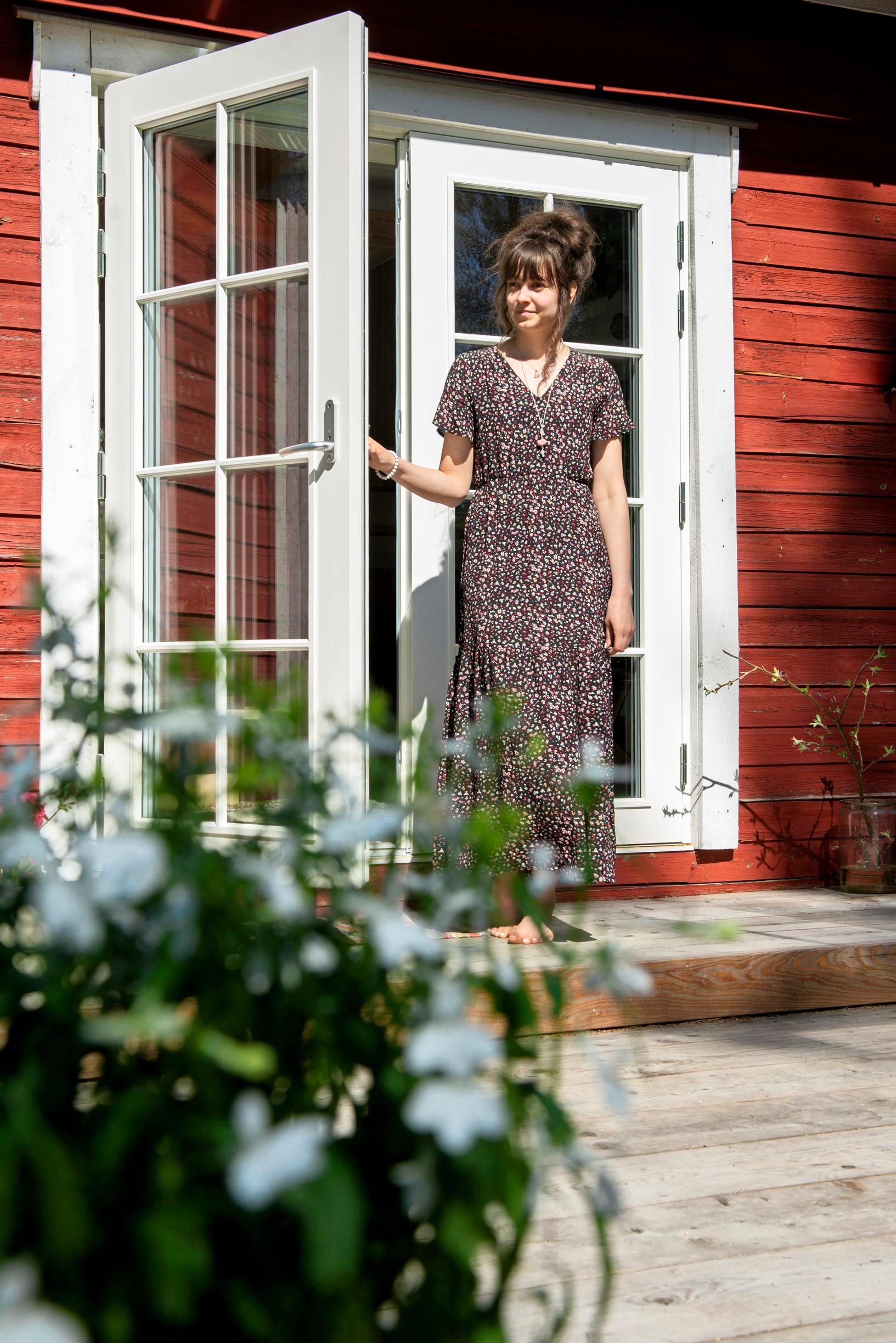 French doors with windows lead from the red cottage to the larch terrace