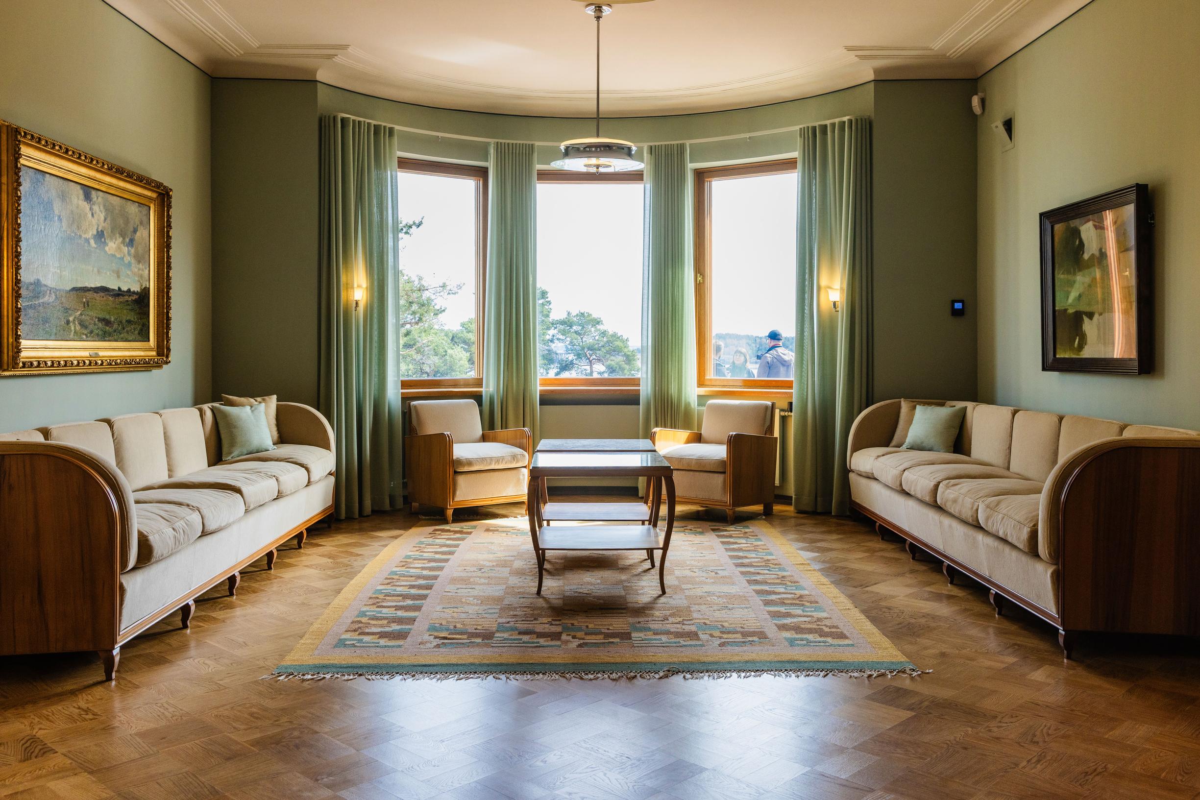 Kultaranta’s living room, with sofas placed against the walls and two small tables in the center