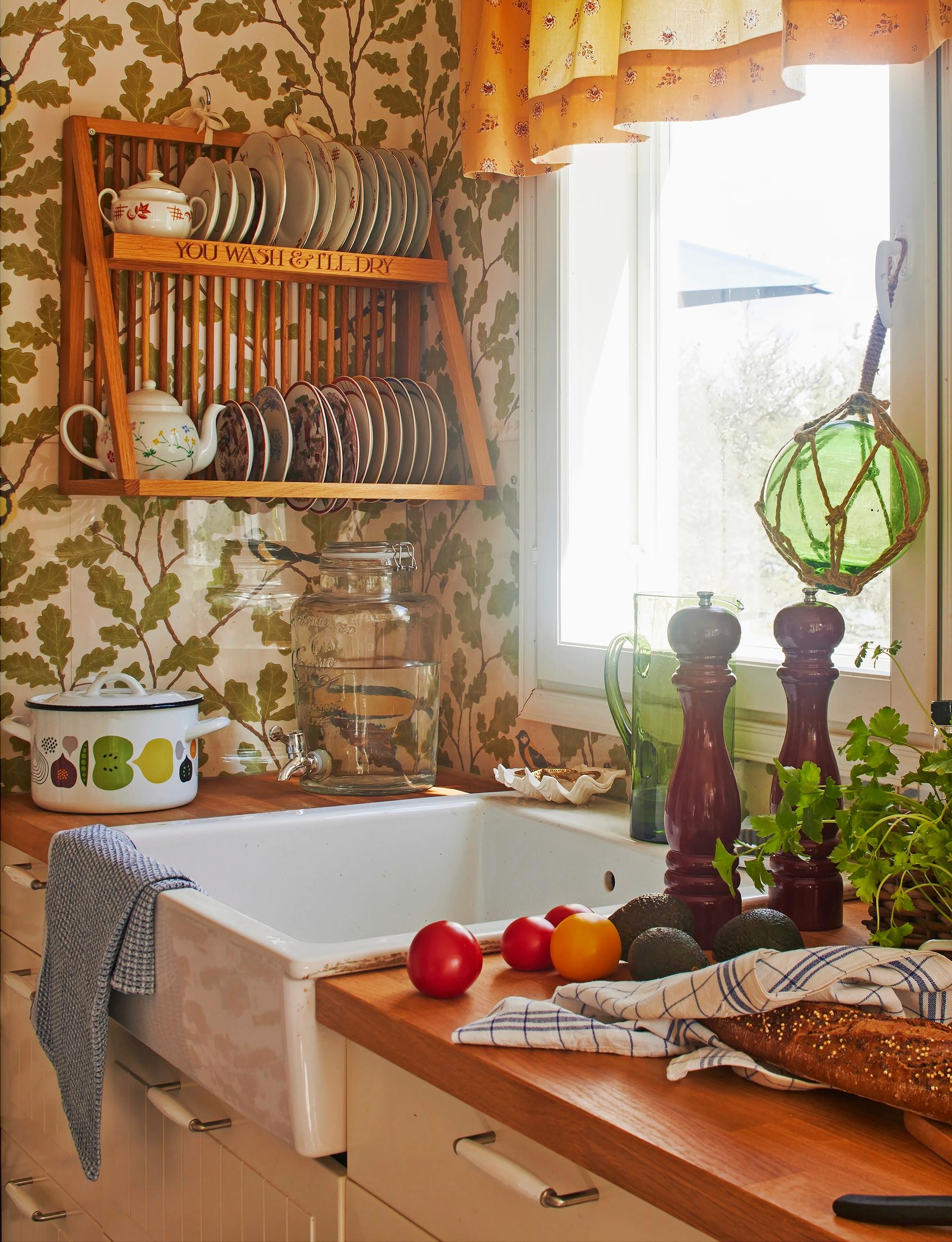 kitchen sink and countertop items, open dish shelf, patterned wallpaper