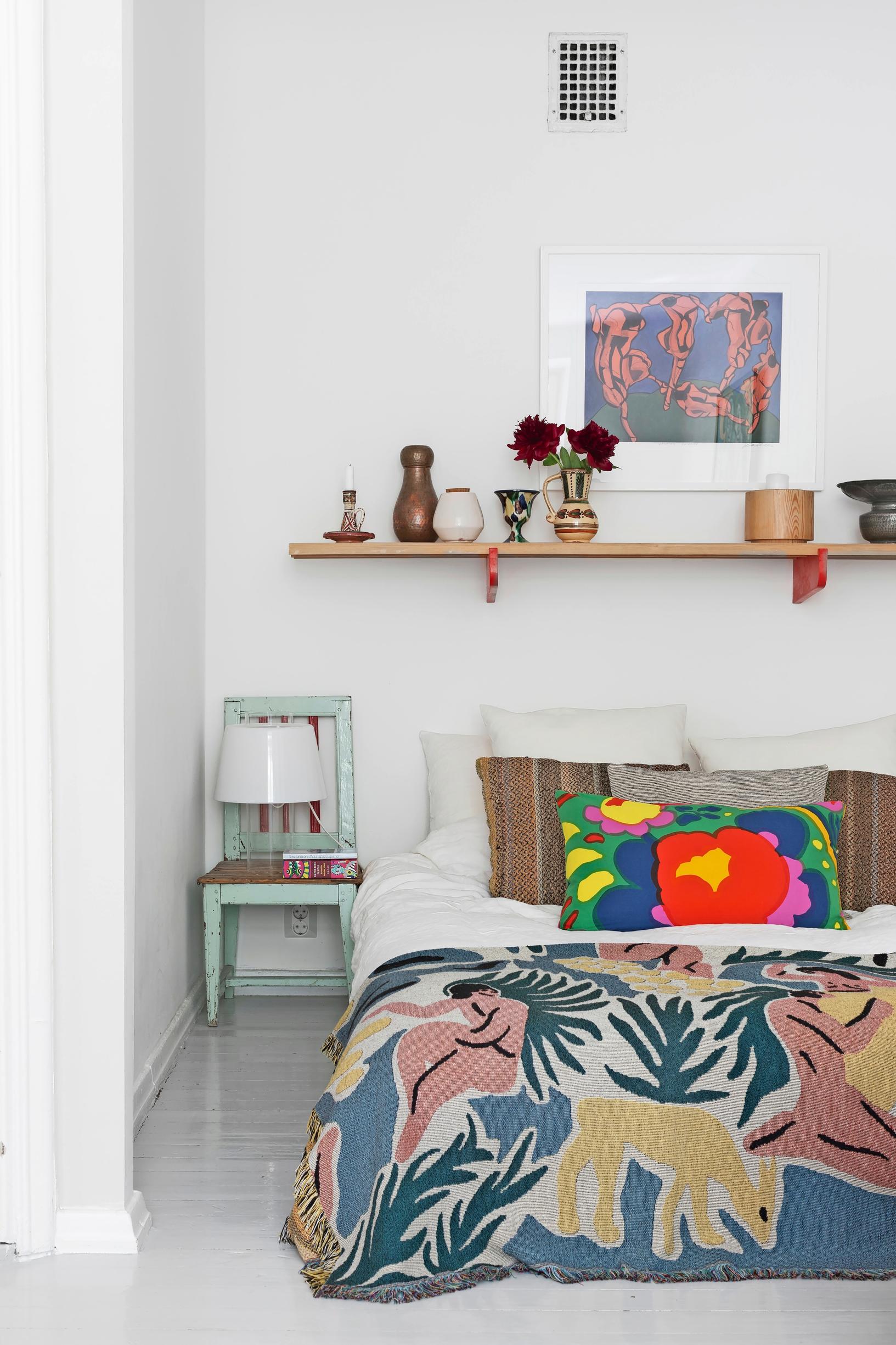 A sleeping alcove with colorful textiles at the far end of the living room