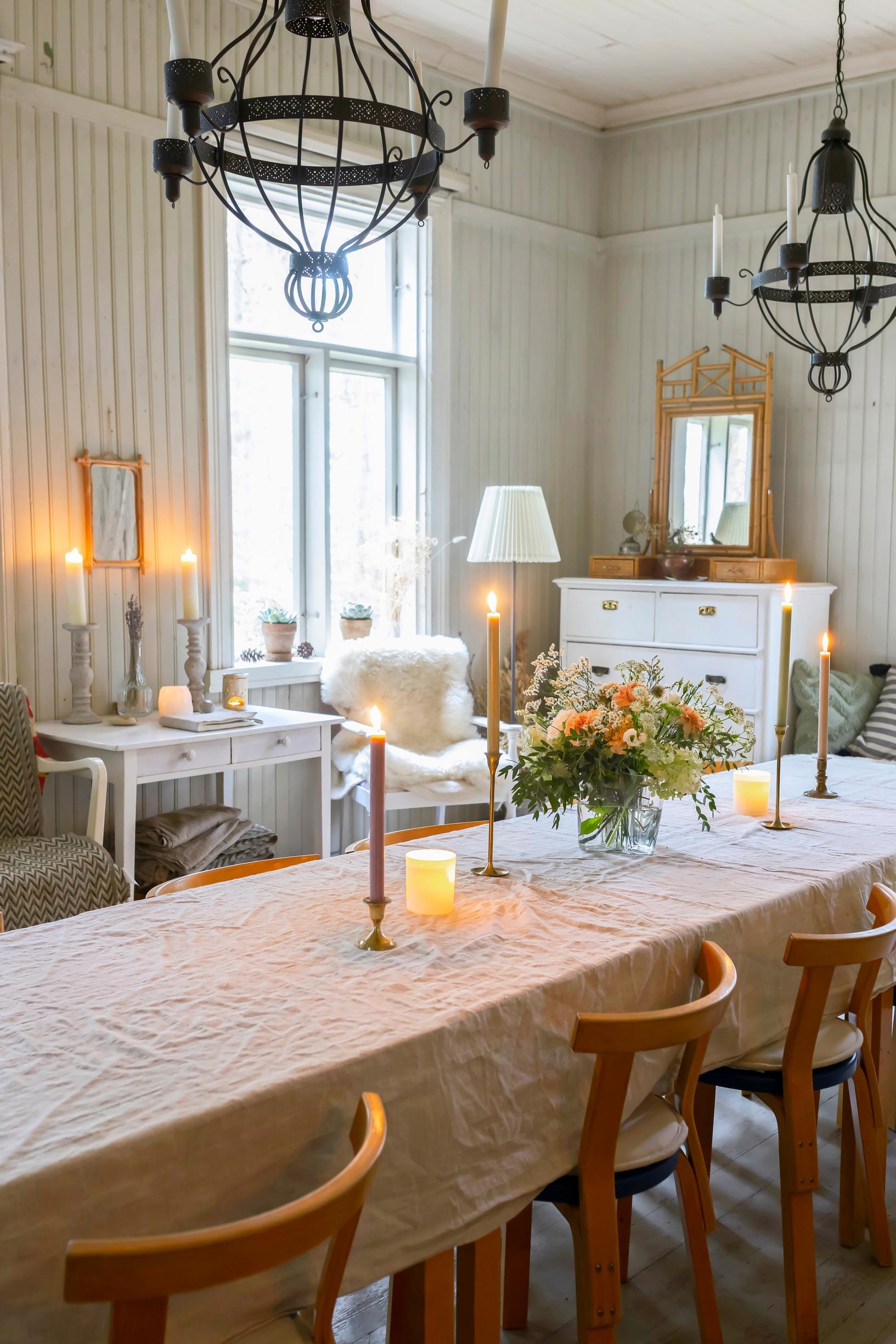Festive living room decorated with candles and white tablecloth.