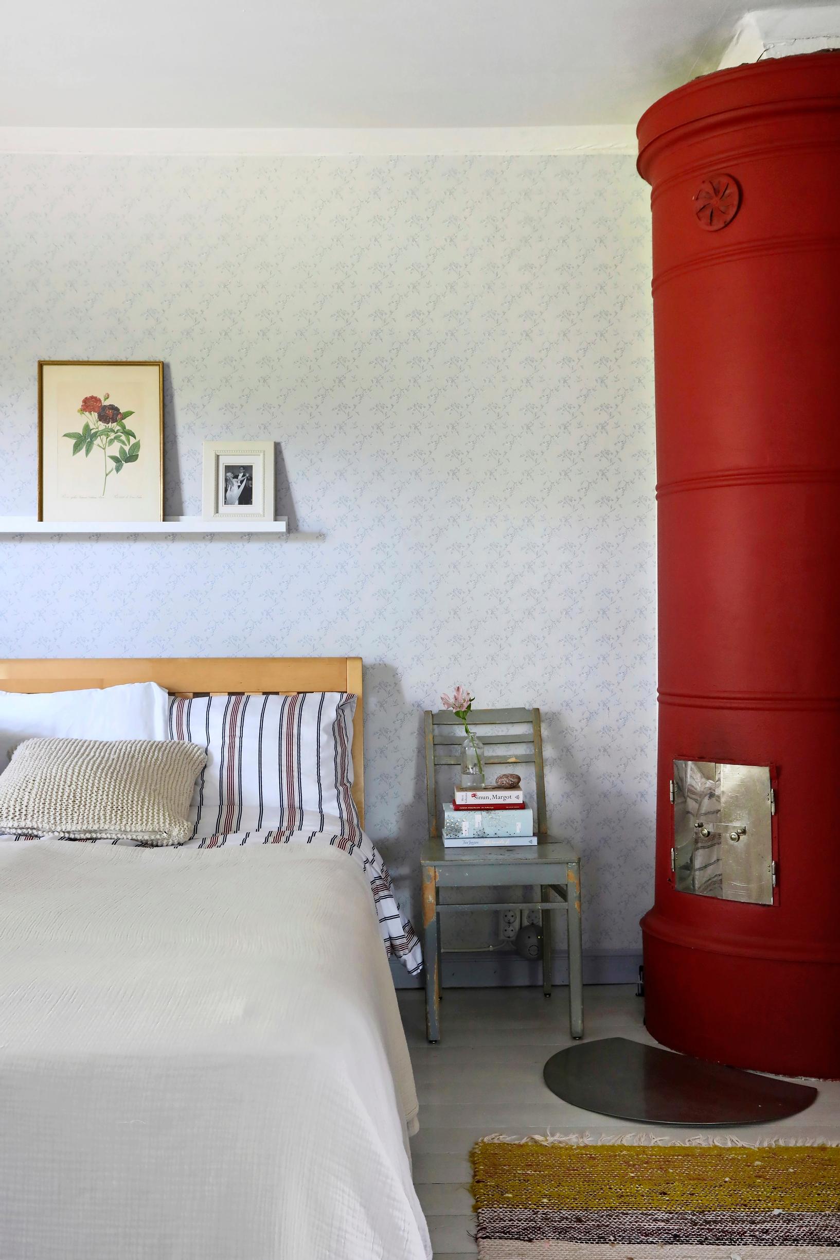 Bed, chair, shelf, and red masonry stove