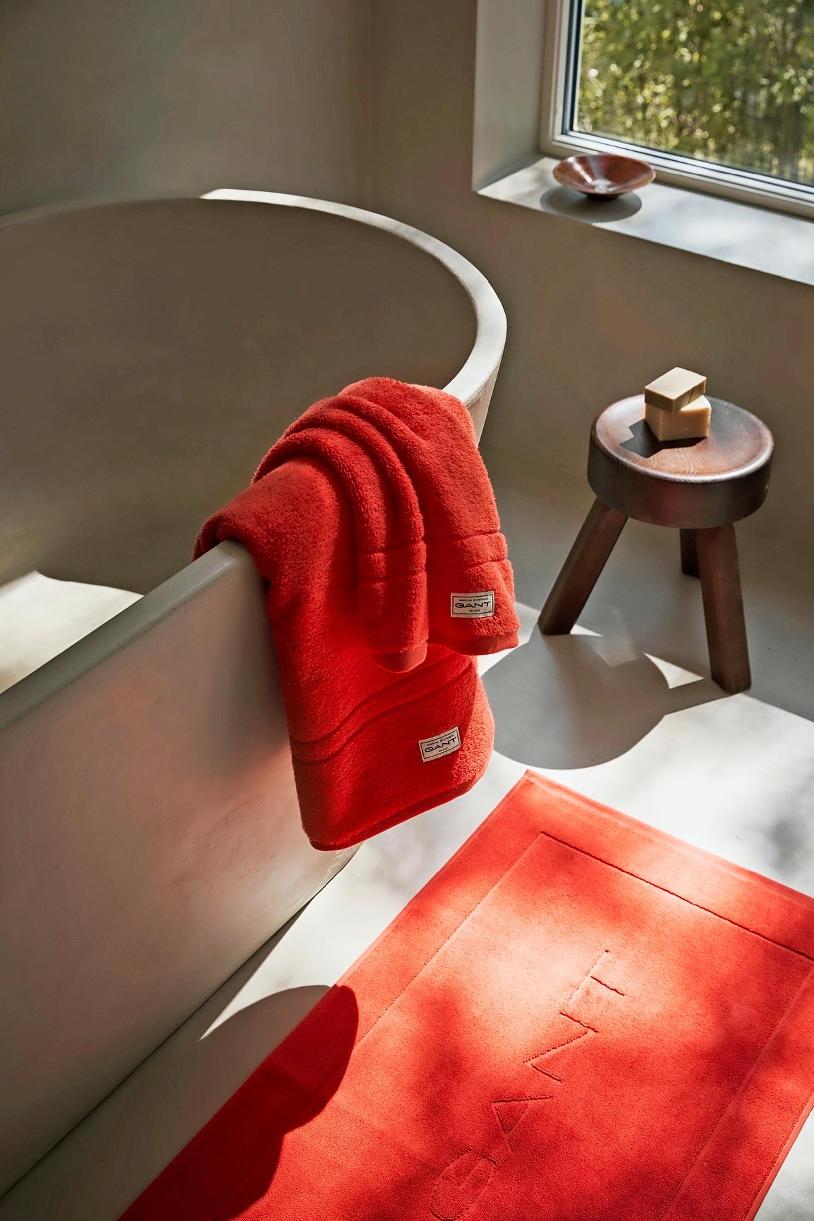 Red Gant Home Premium towels on a bathtub edge
