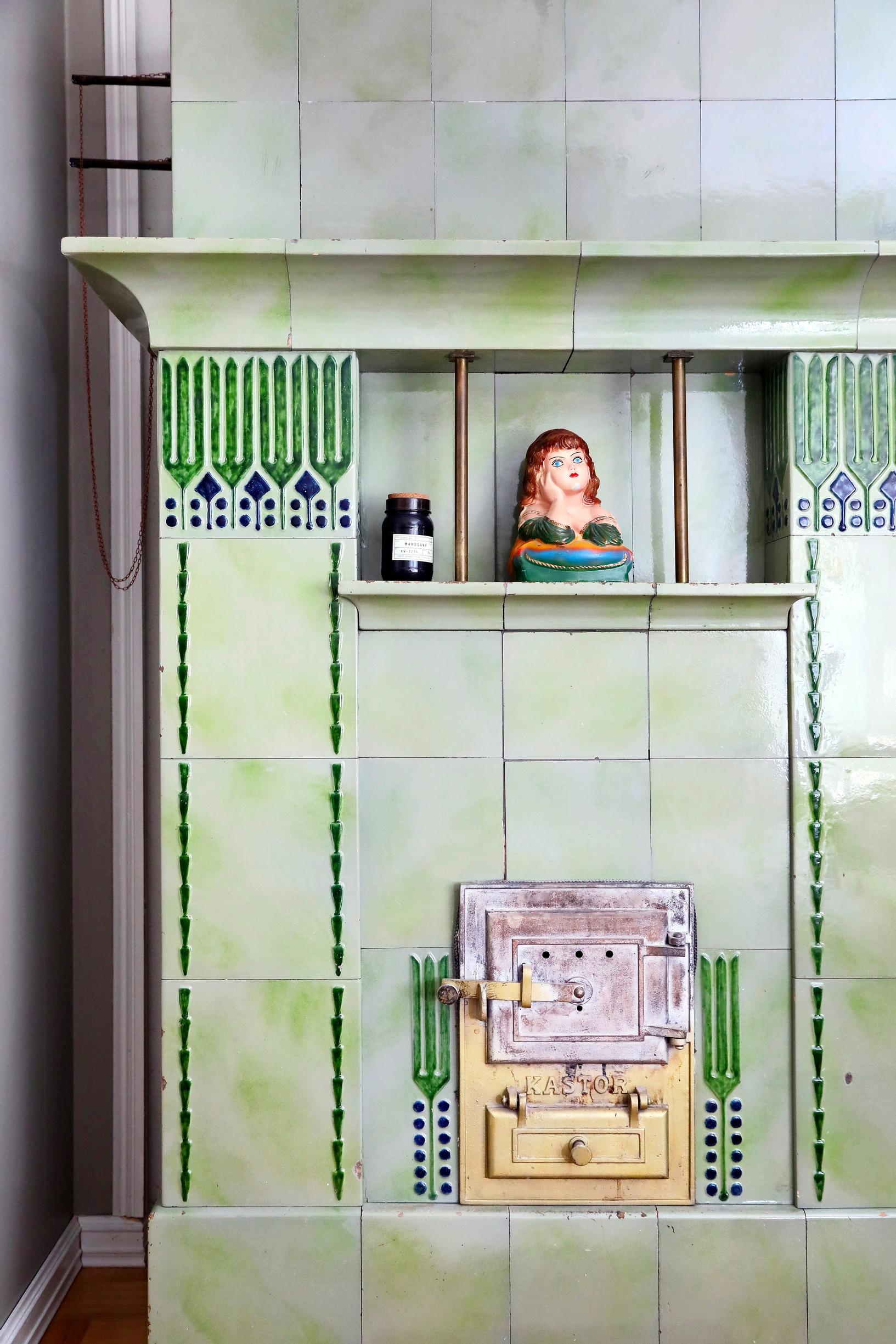 green tile stove with Egyptian-style decorations and ornamental objects