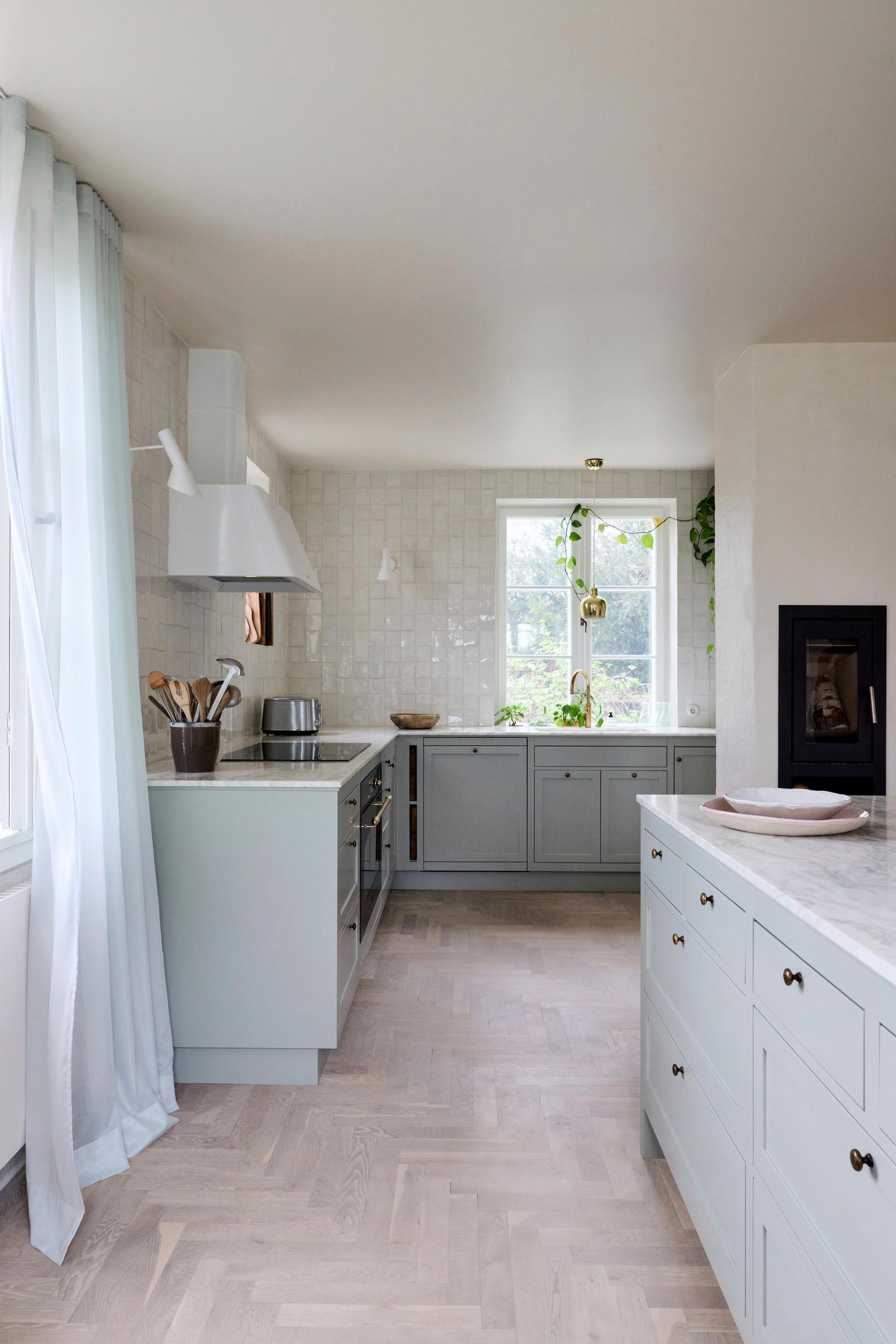 A mint-green solid-wood kitchen with a view of the garden