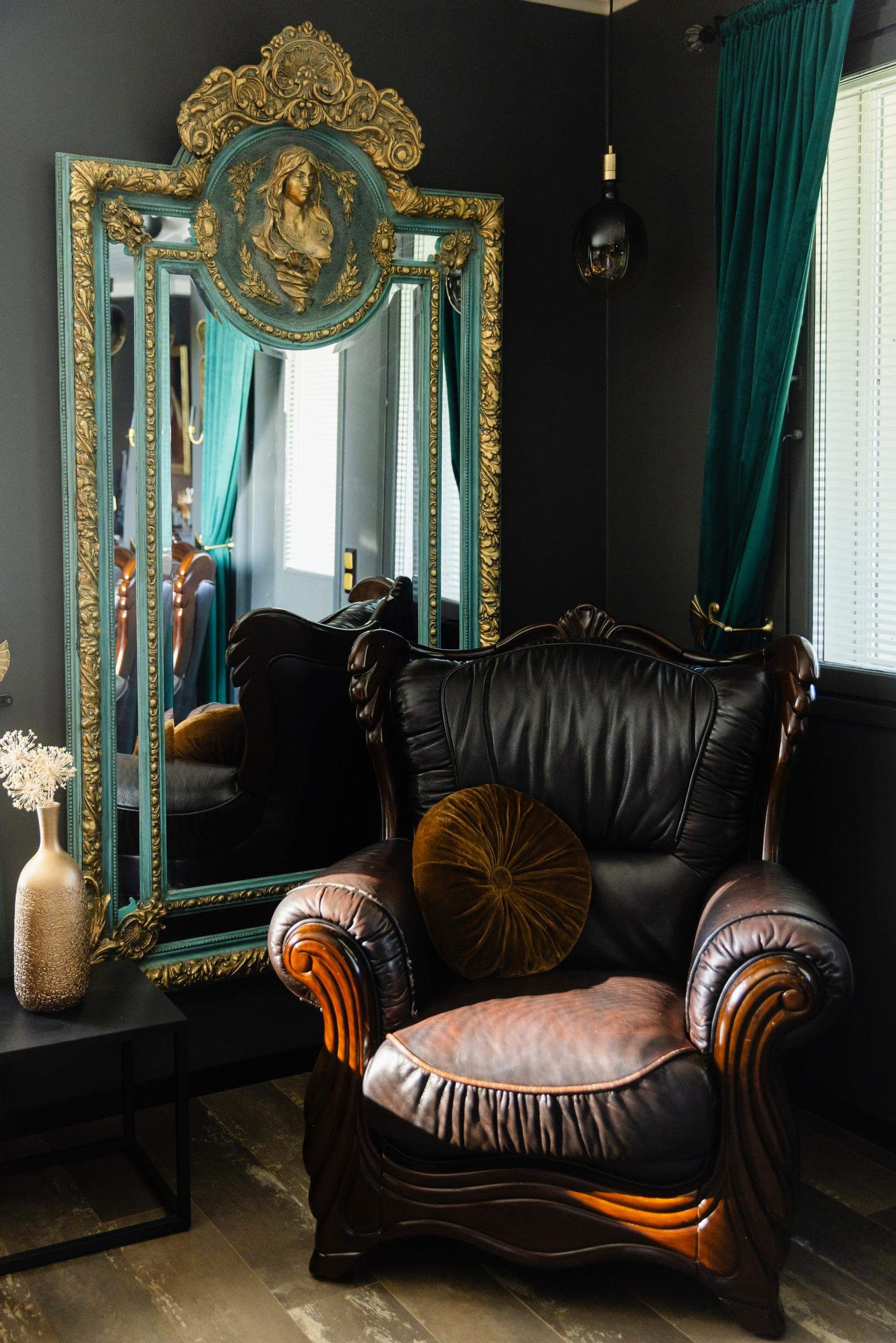 Large gold mirror and leather armchair