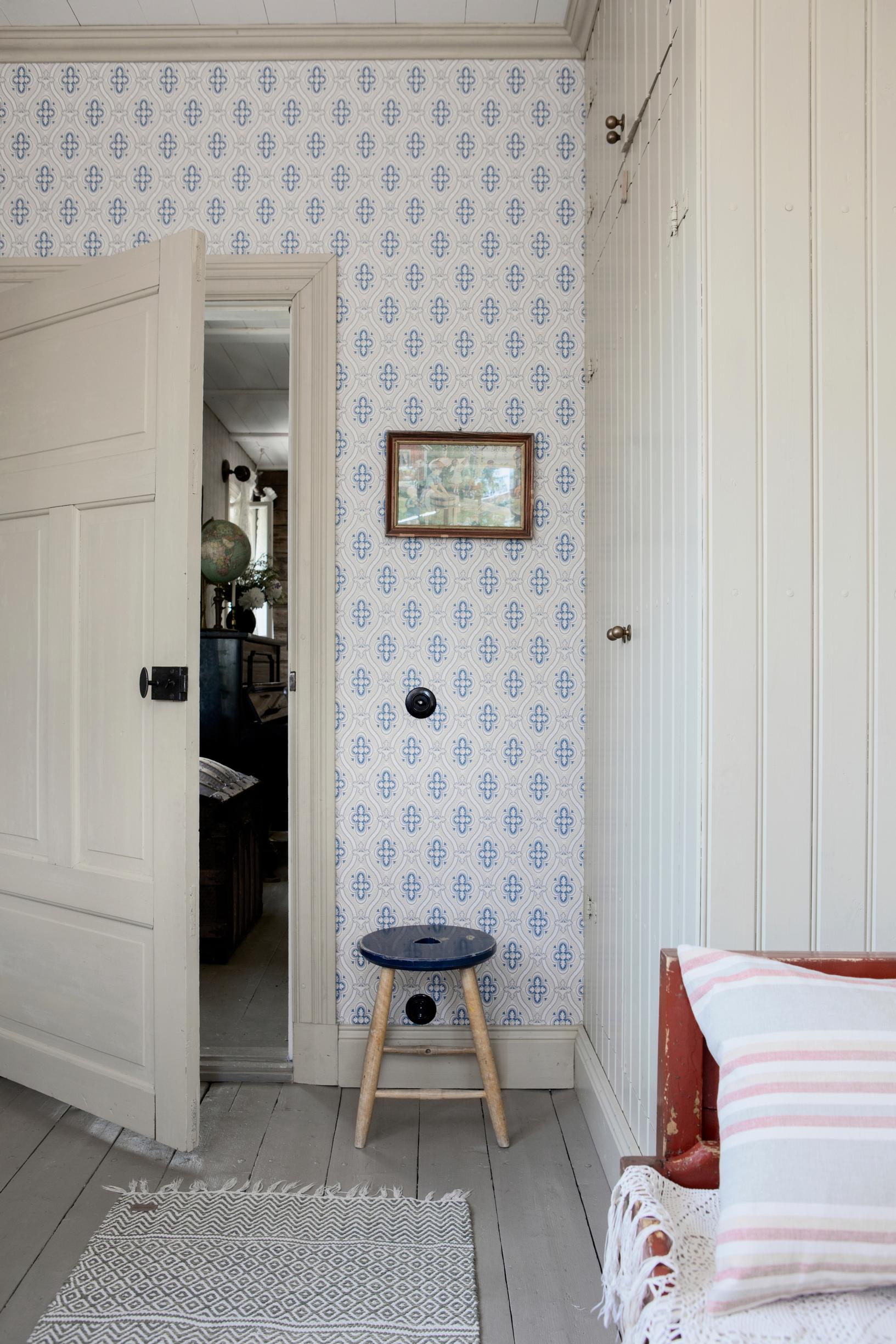 Blue-and-white wallpaper and a gray-painted plank floor