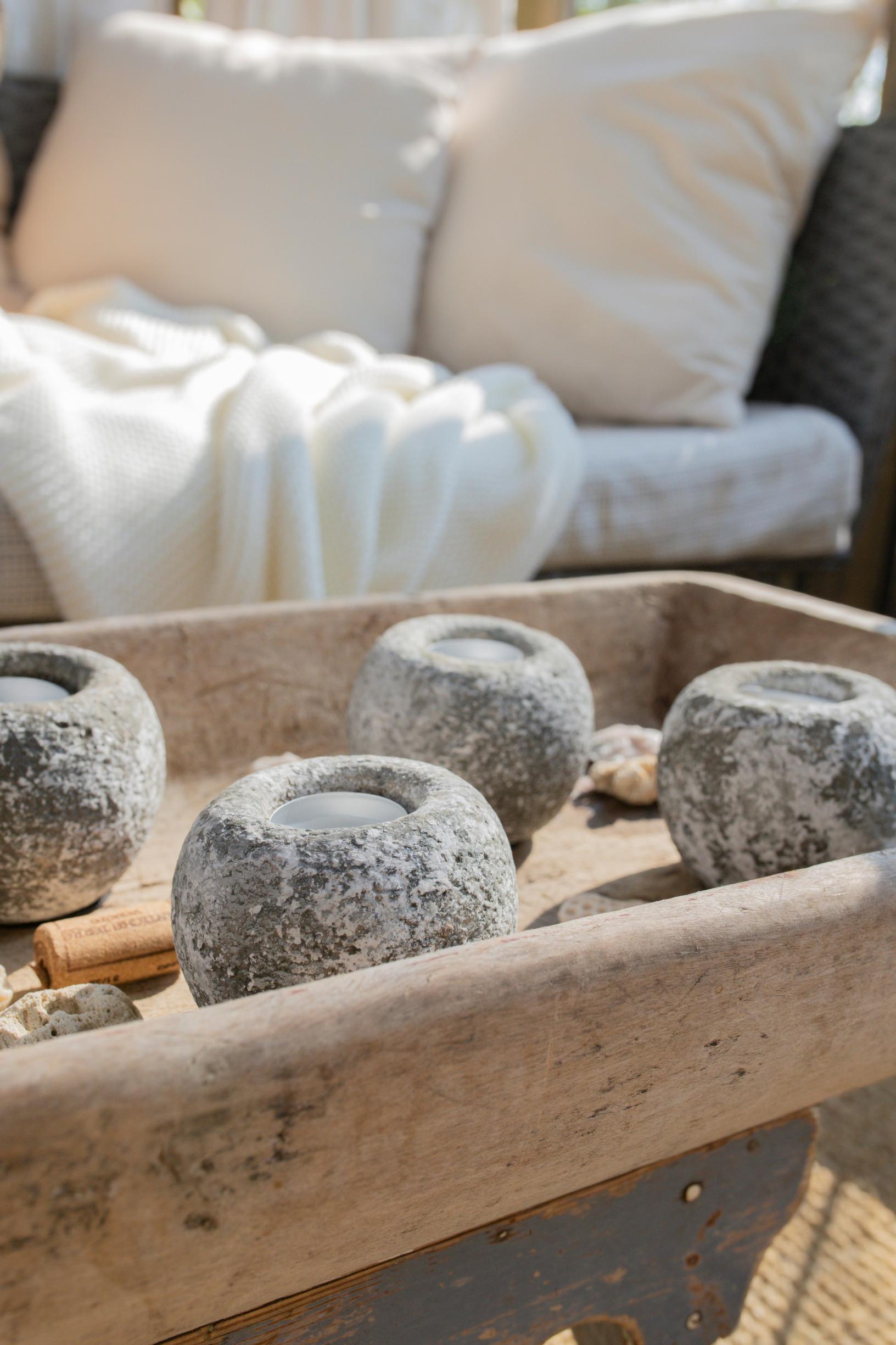 stone tealight holders on a wooden tray