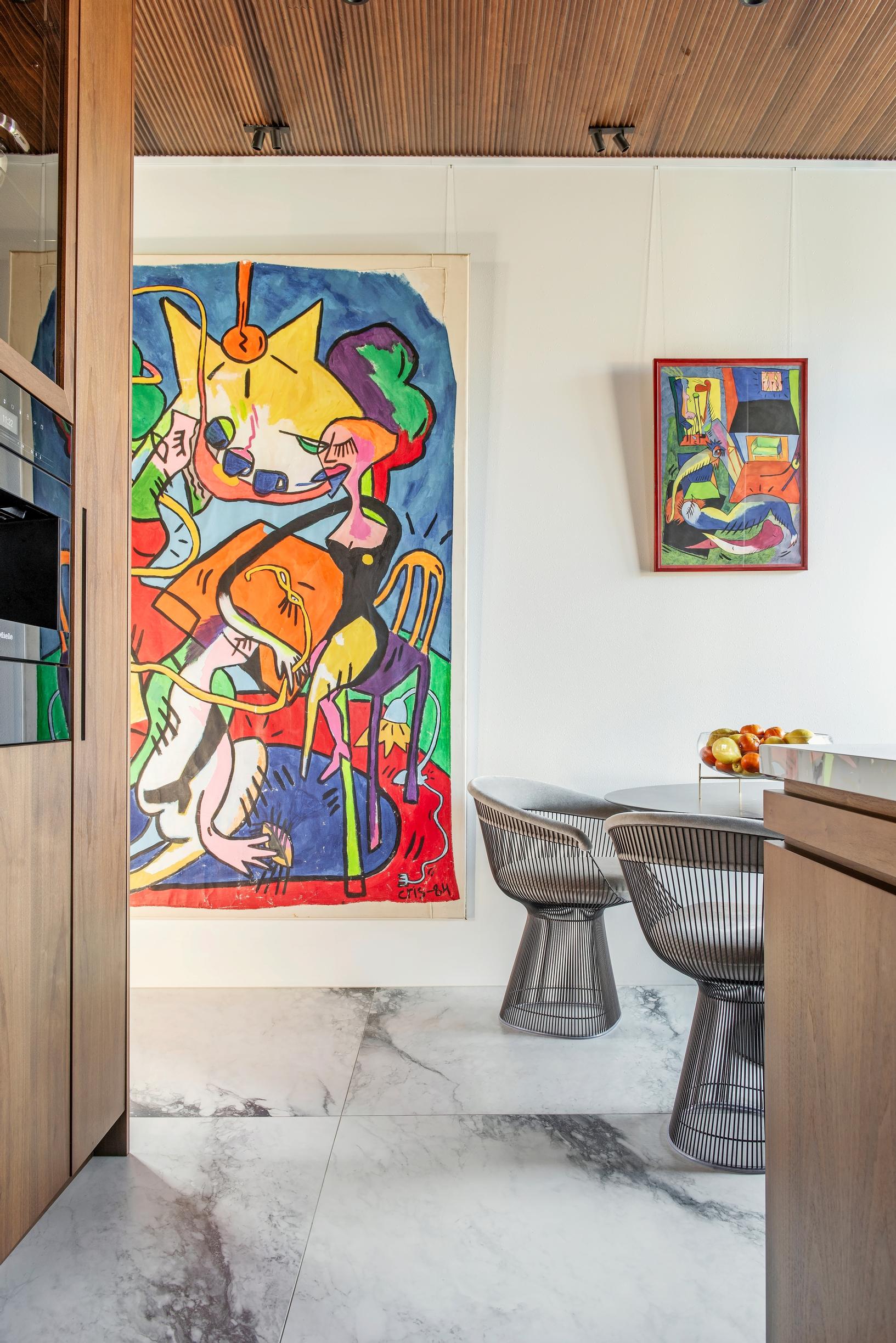 In the everyday dining area, marble-patterned floor tiles and designer furniture