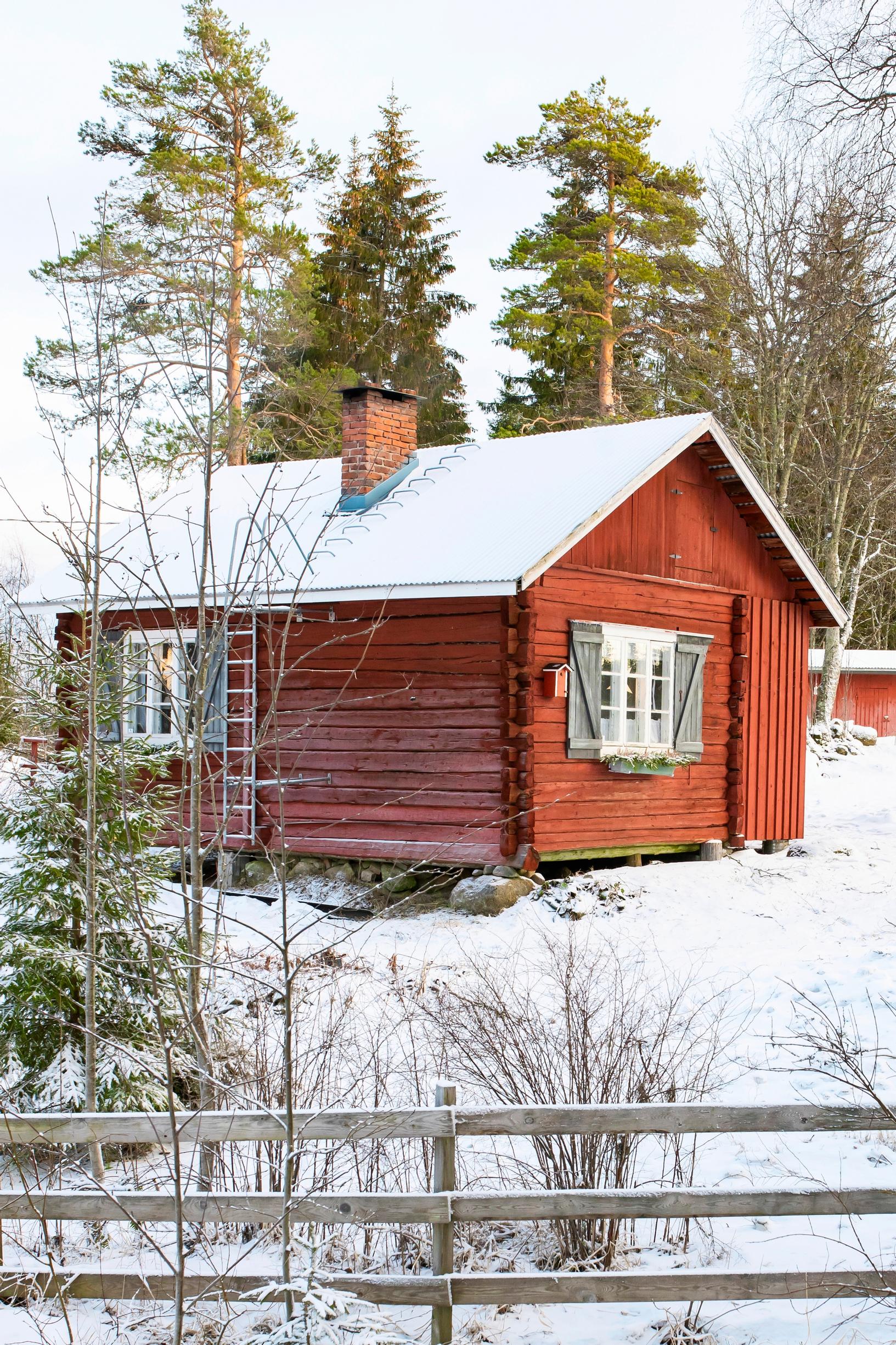 A small log cottage in a winter landscape