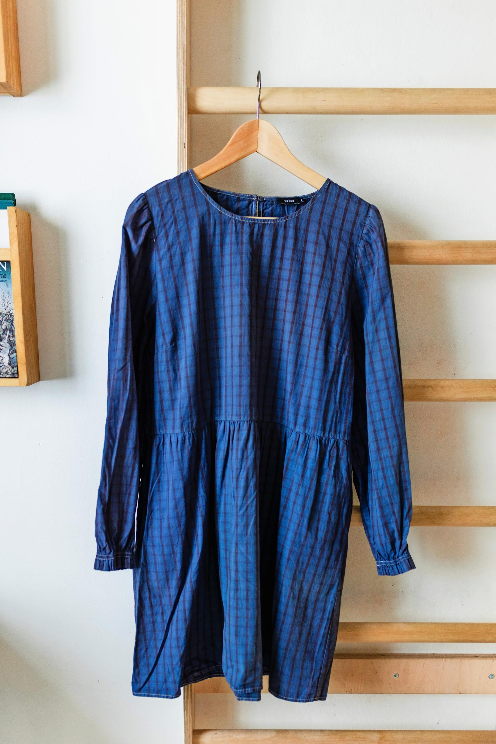 A blue-toned dress on a hanger.
