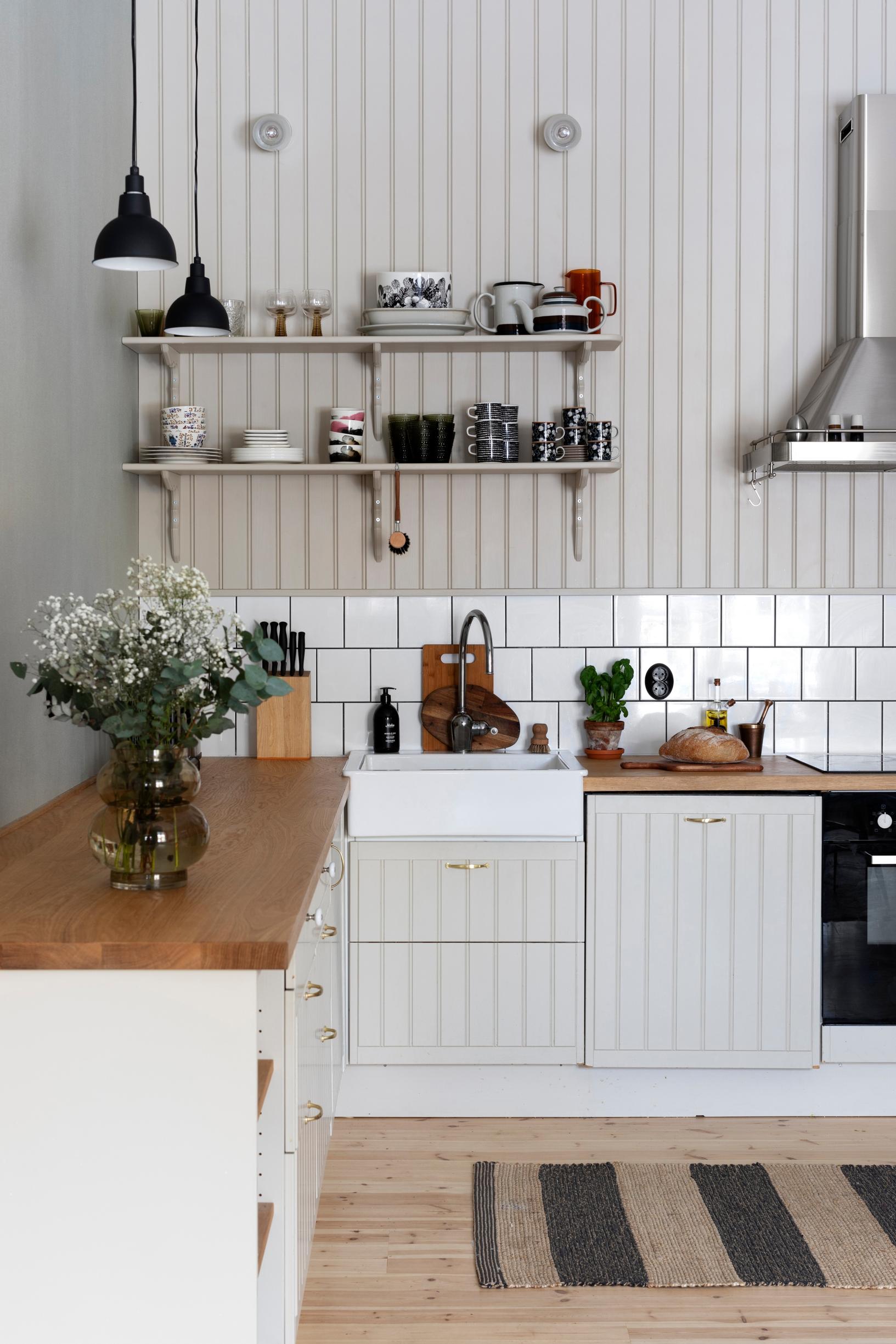 A rustic-style kitchen featuring open shelving and beadboard paneling.