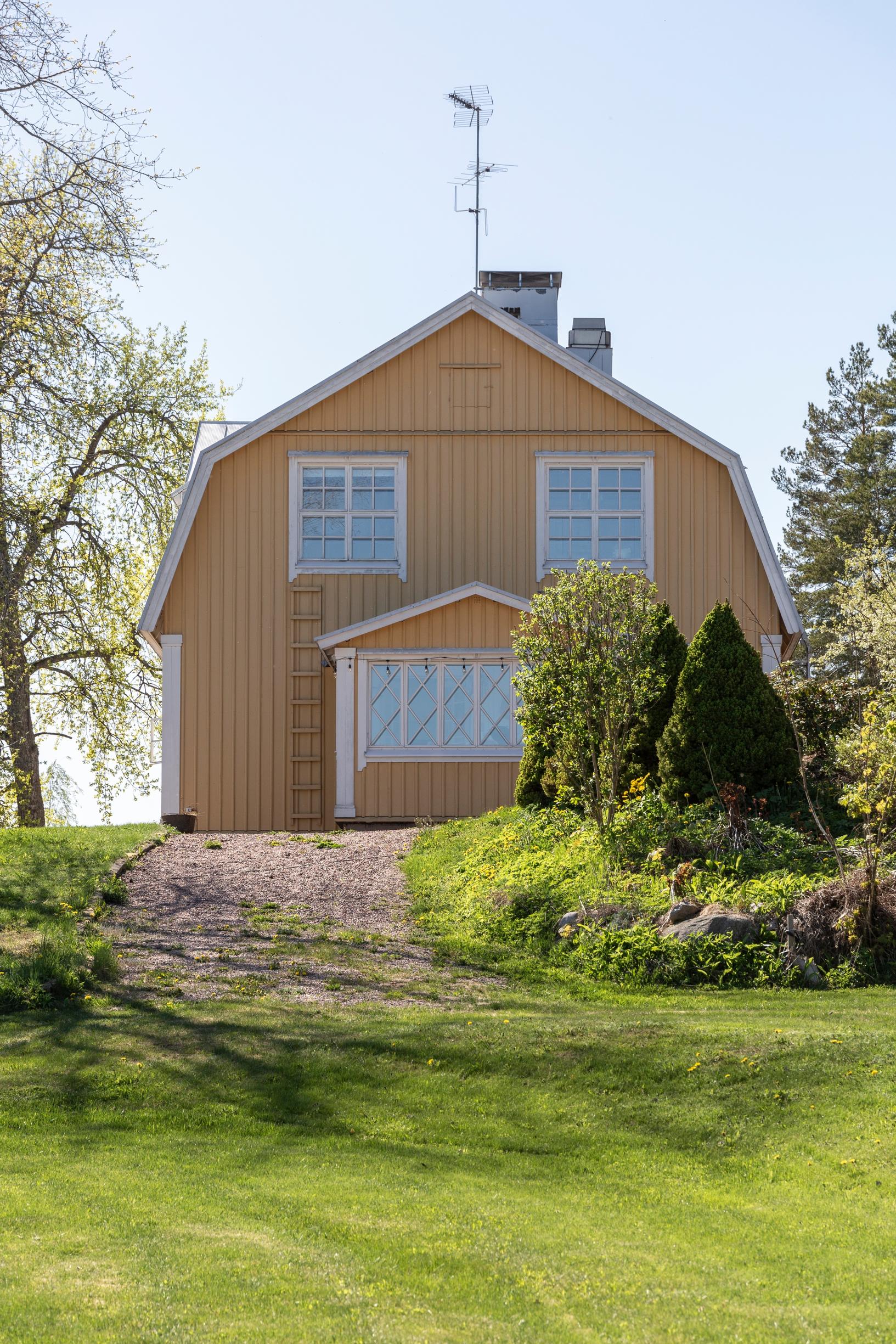 Yellow historic log house perched on a hill