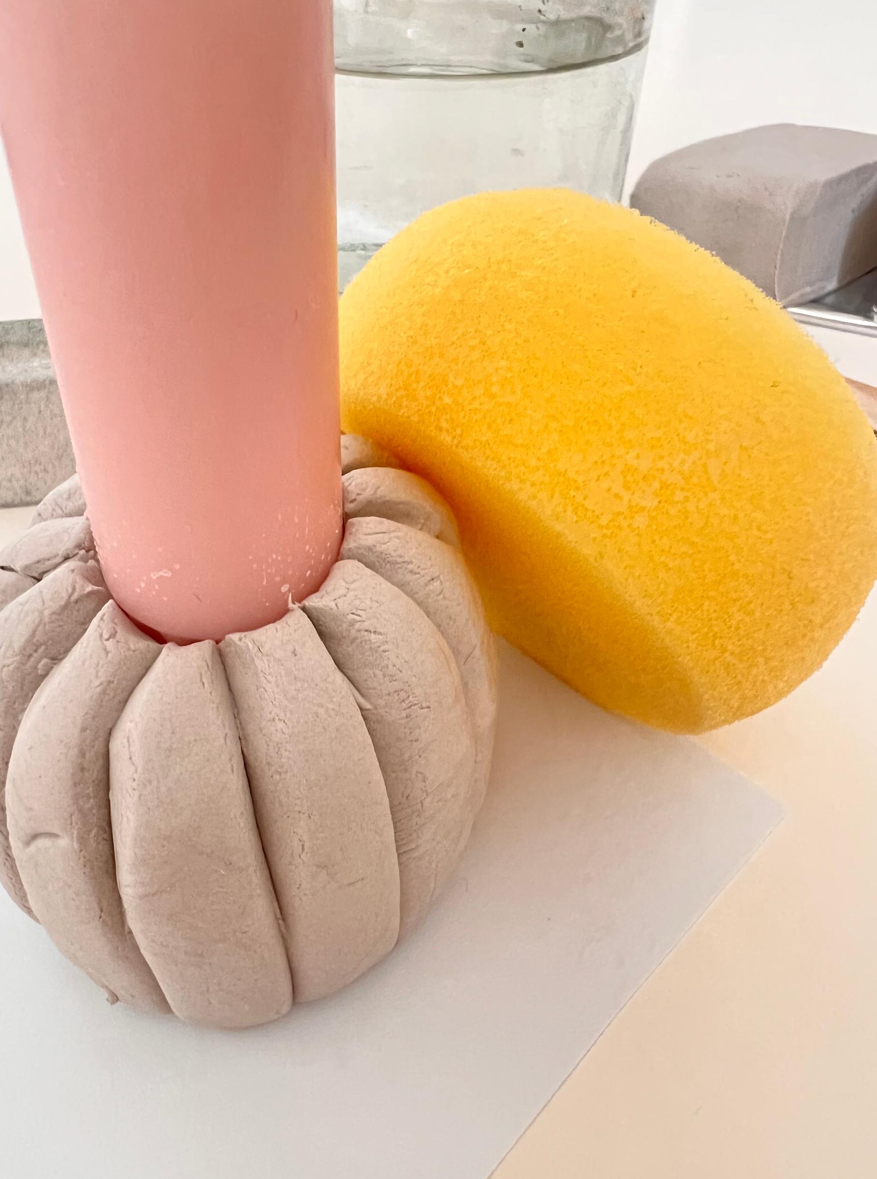 Smoothing the clay’s surface with a damp foam sponge.