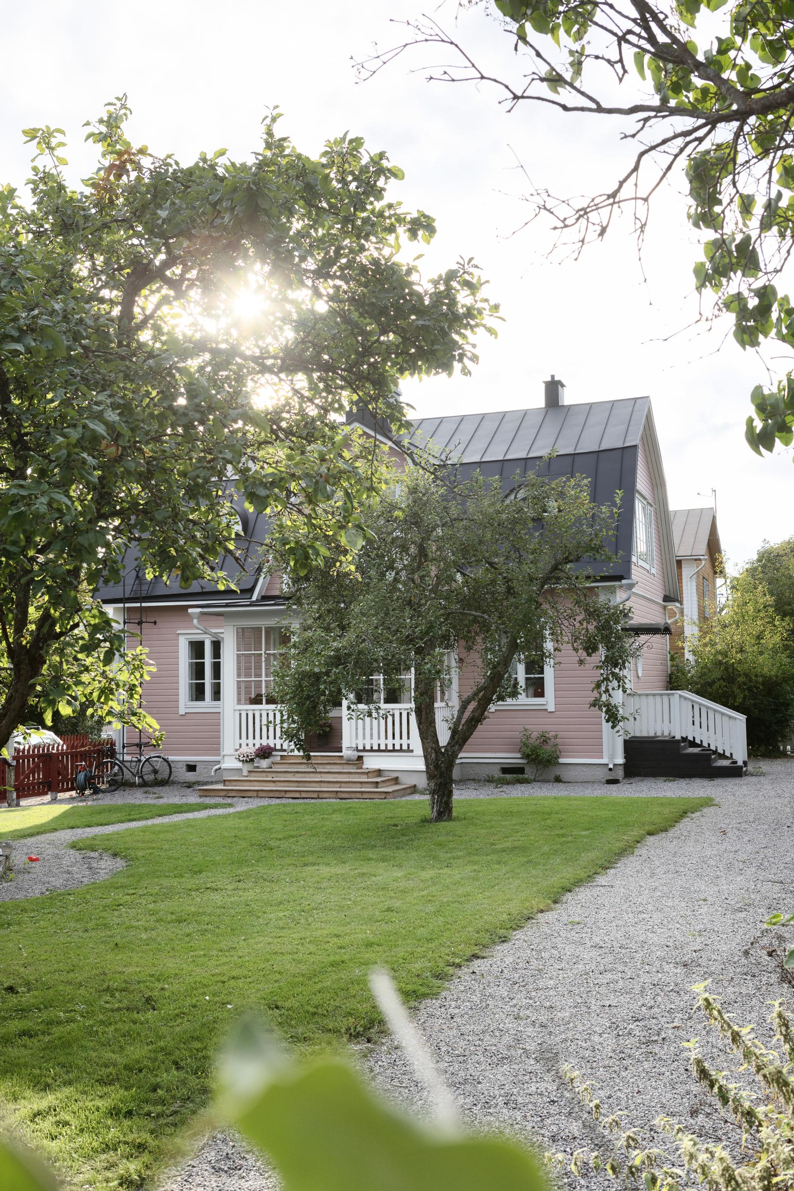 a pink wooden house and garden