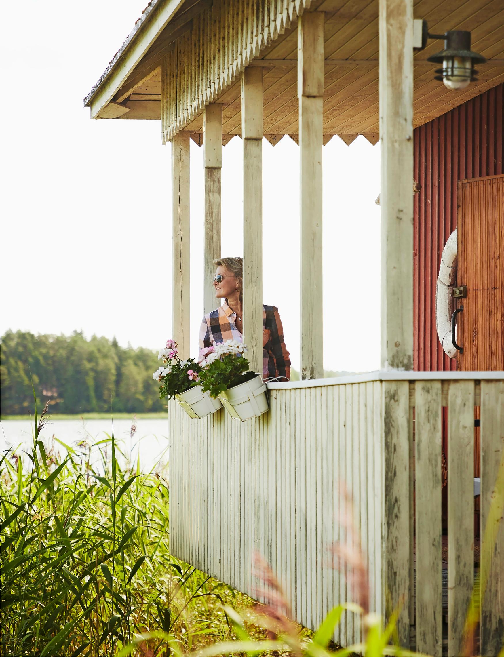 Heli gazing at the sea from the sauna veranda, flower pots, reeds, opposite shore