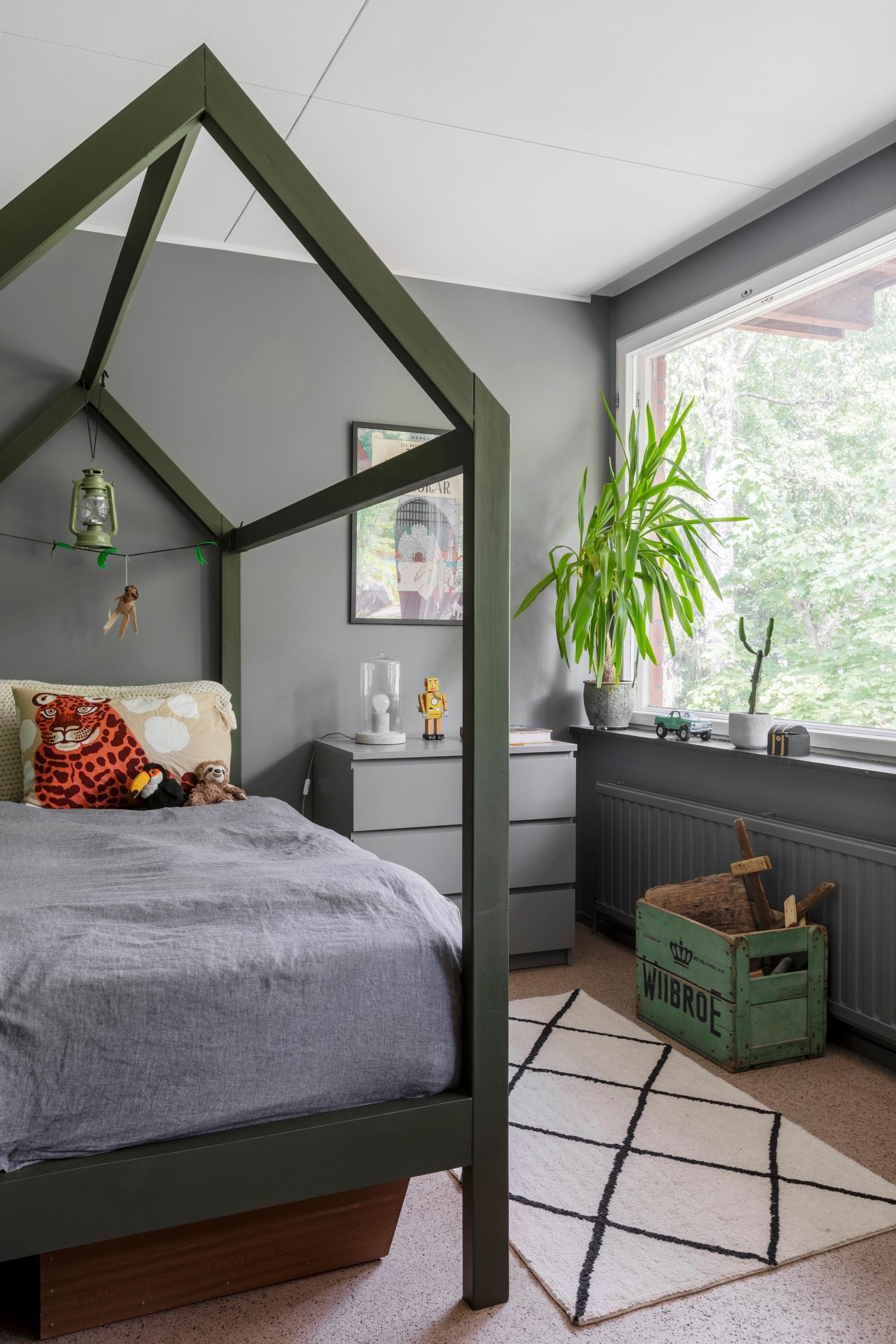 The bed in the children’s room with a gable roof-like canopy frame