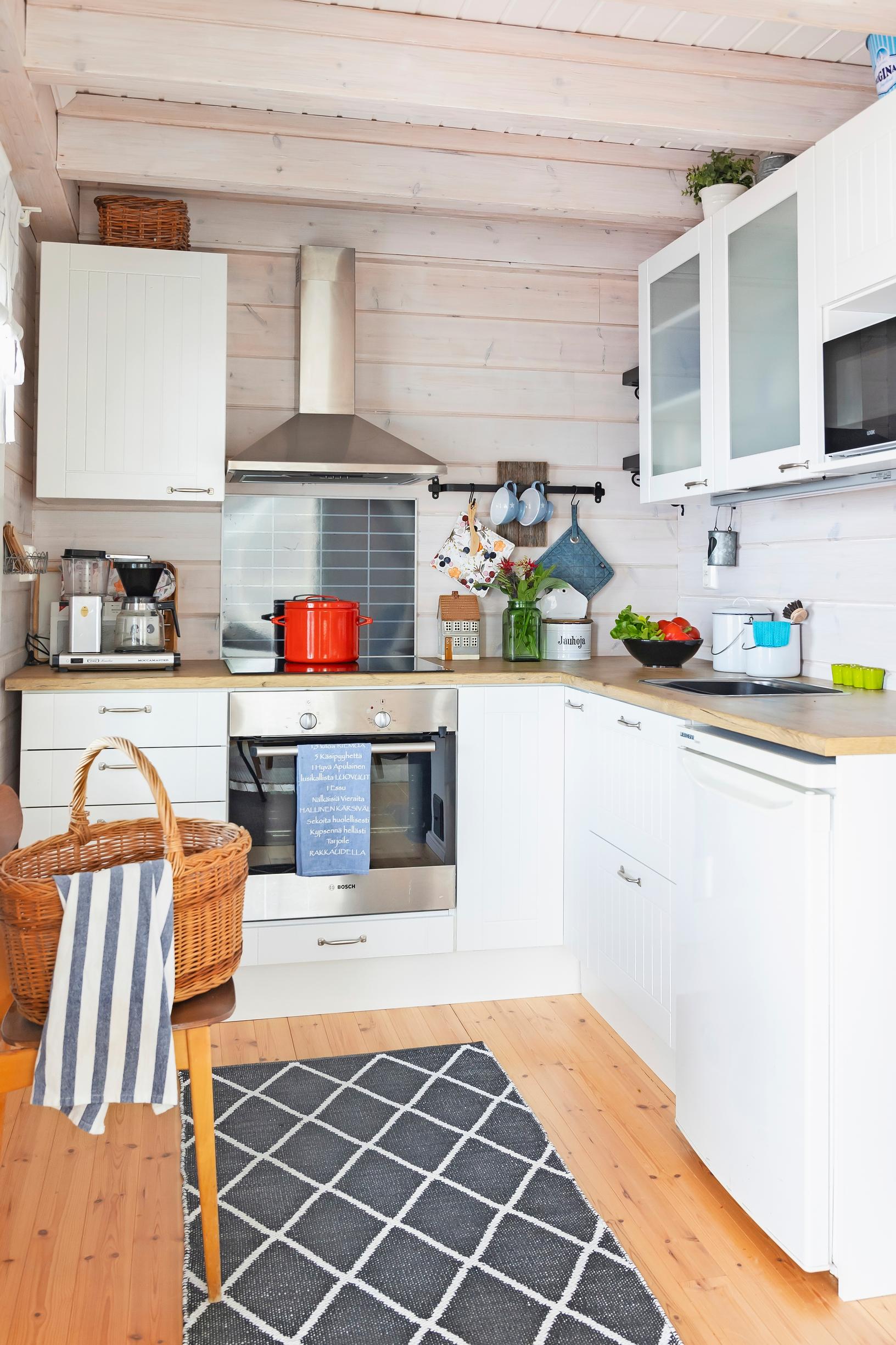 a light-colored kitchen and a checkered rug
