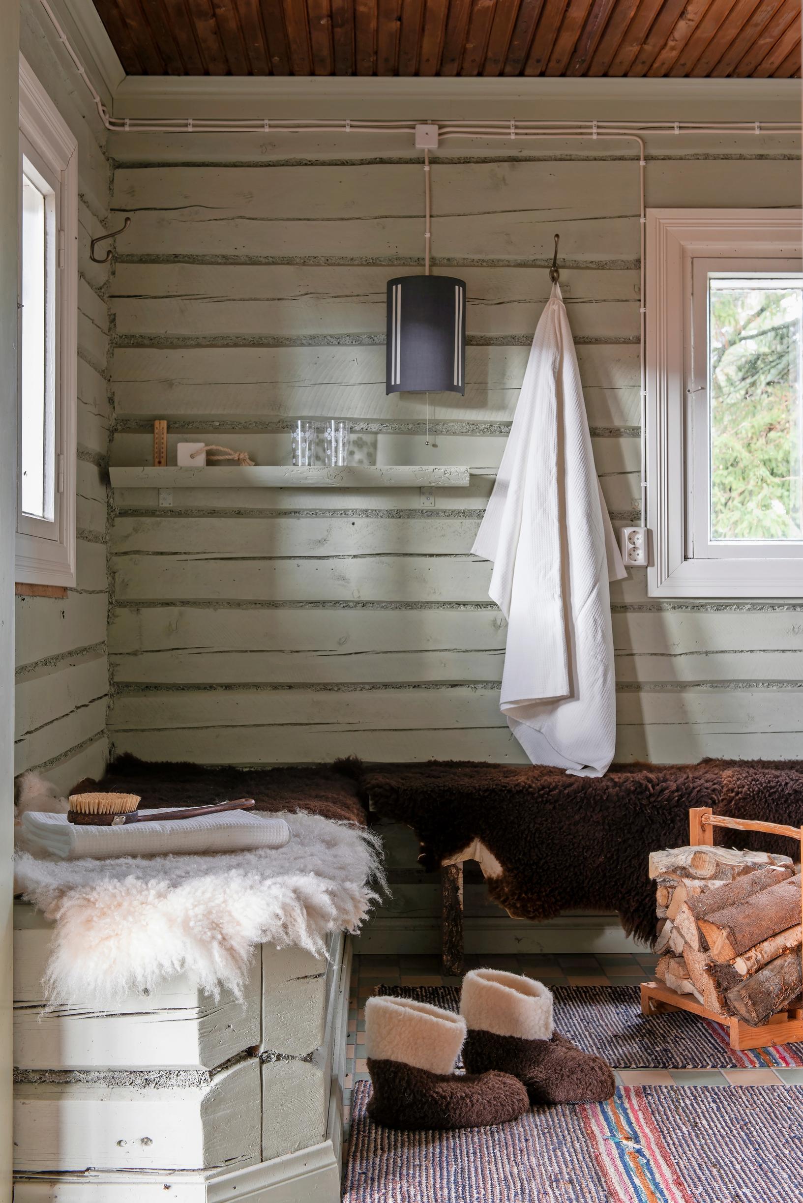 The changing room of an old sauna building, featuring green log walls