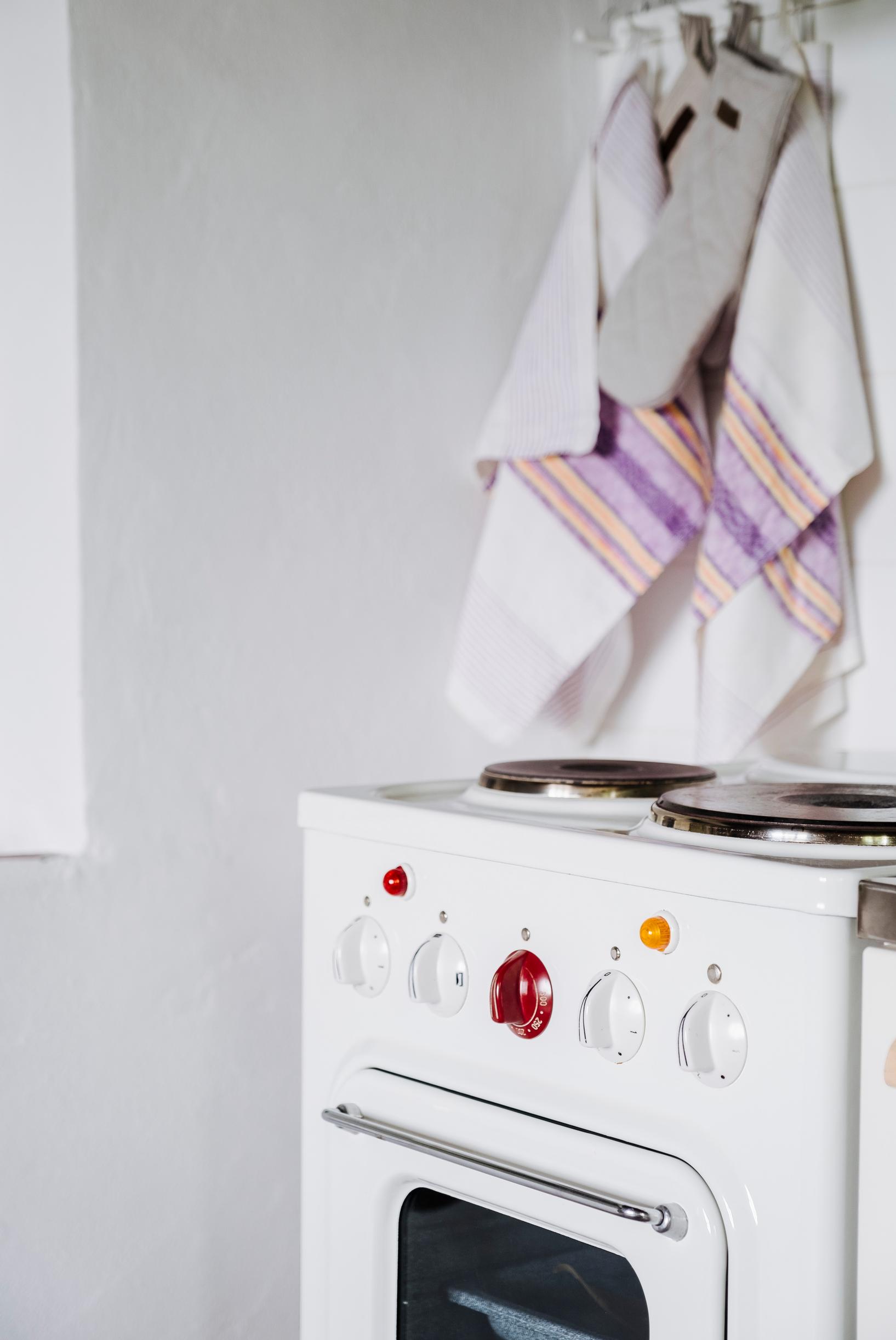 Old electric stove and kitchen towels hanging on a hook