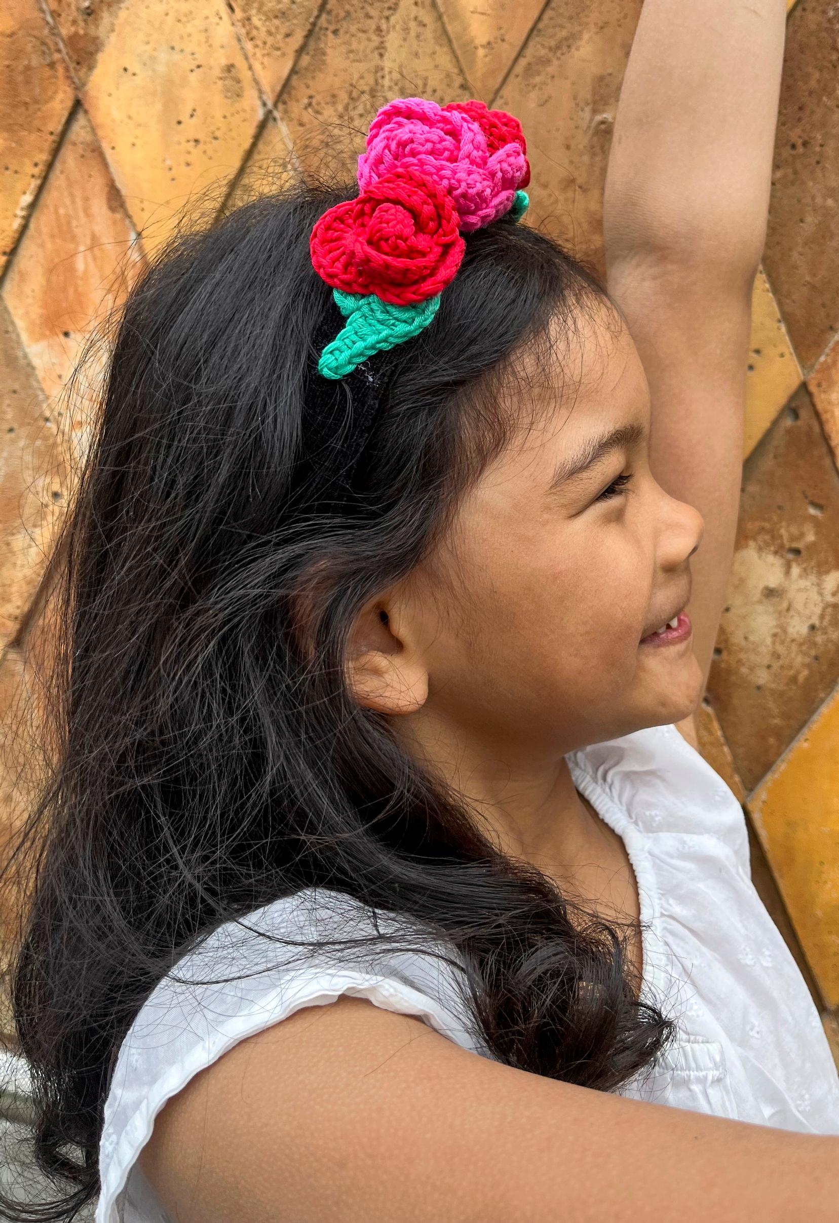 A child wearing a crocheted rose headband