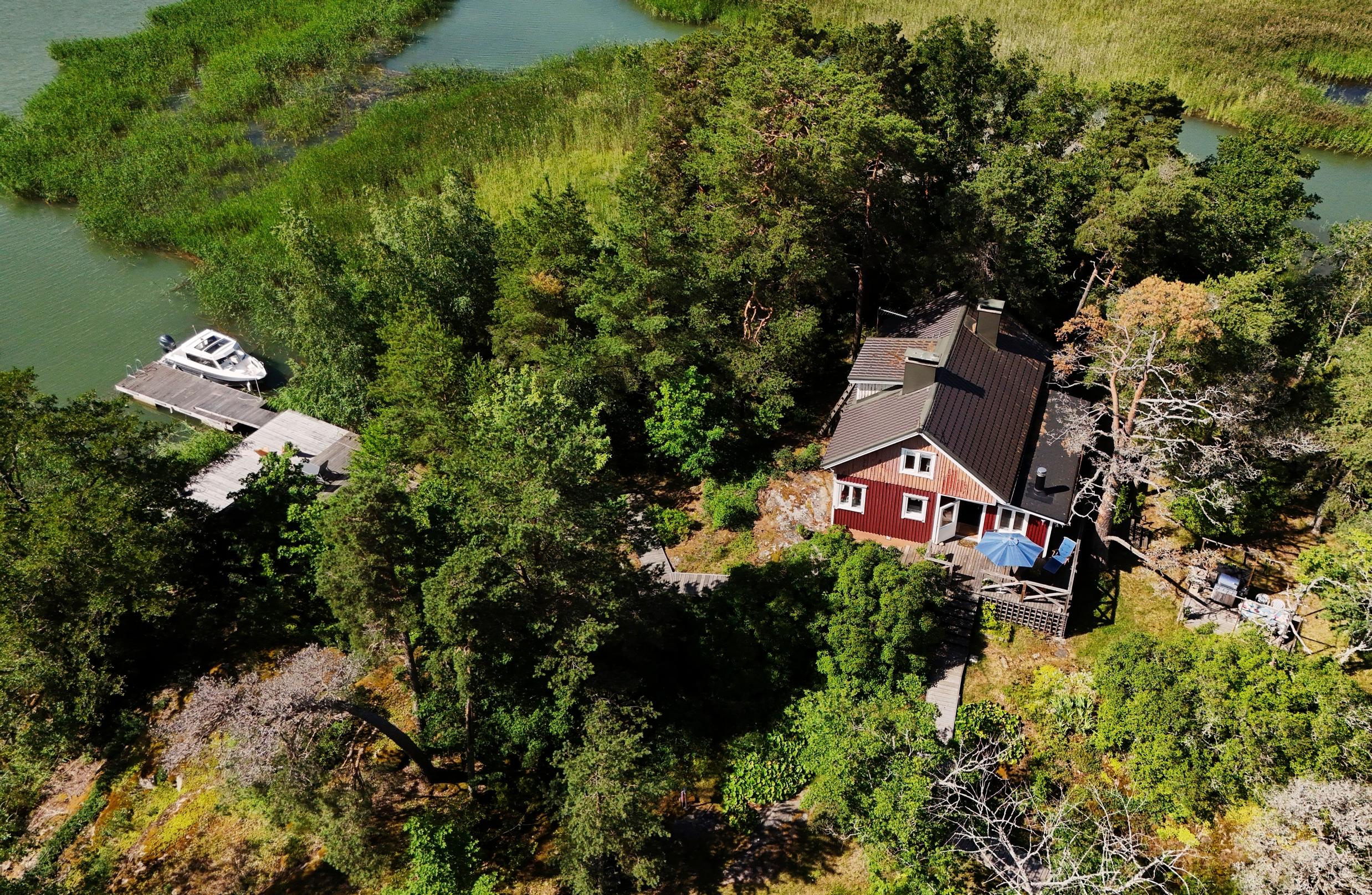 An aerial view of Heli’s island cottage: rock outcrops, forest, a dock and the sea