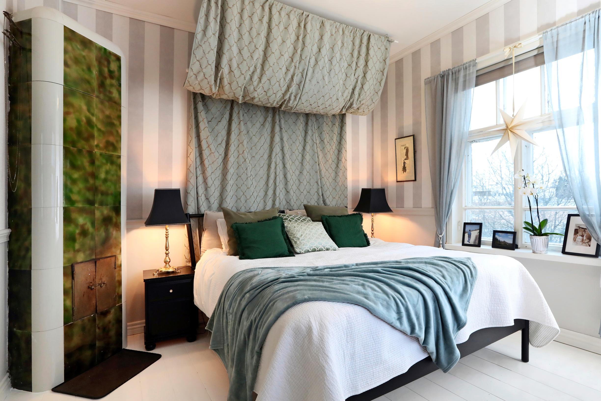 The old riding estate’s bedroom with a striking bed canopy and a green tiled stove