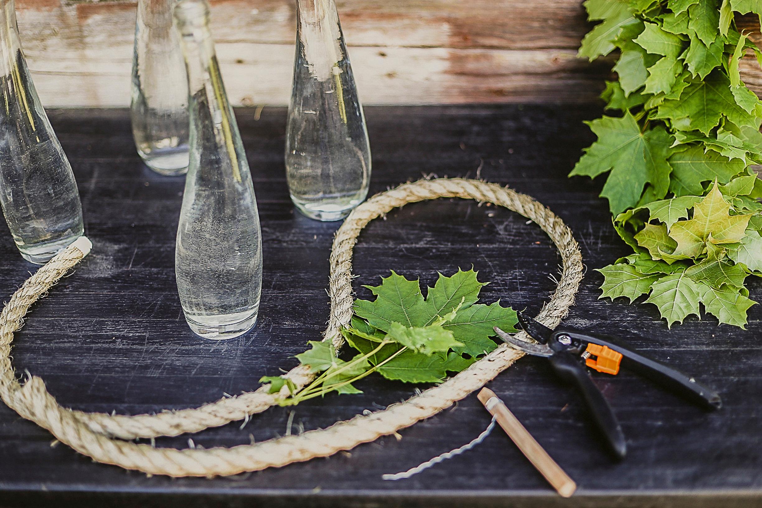 String, maple leaves, and wire cutters on the table.