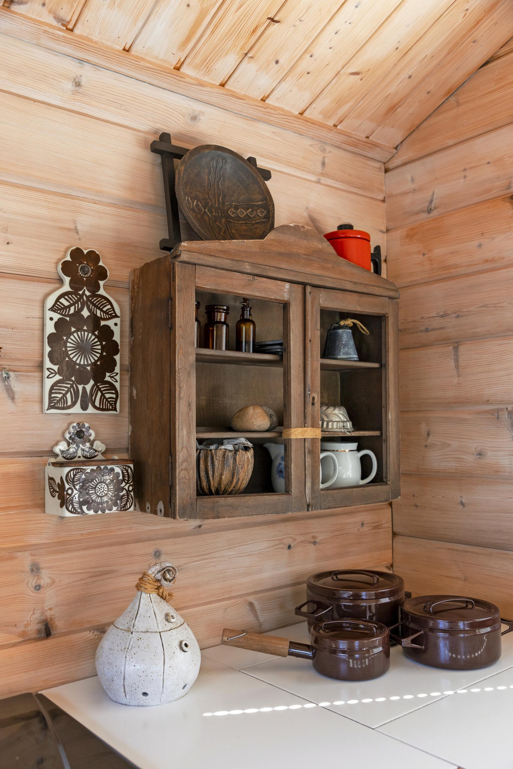 Inside Marita and Eki’s island cottage: a wooden shelf on the wall with old dishes