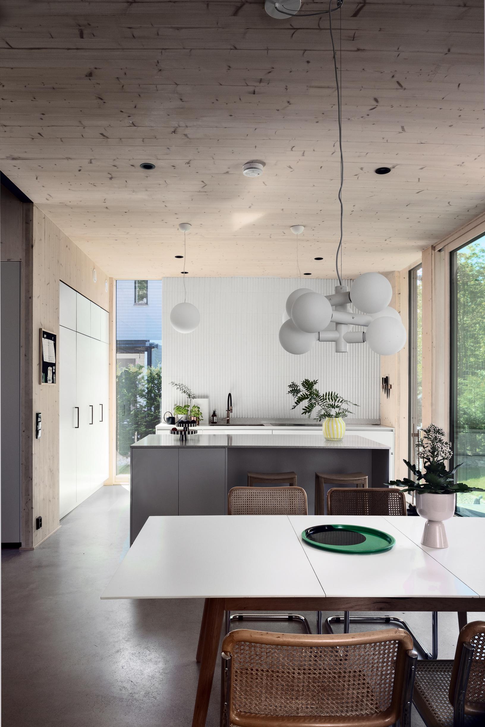 The kitchen has an island behind the dining table.