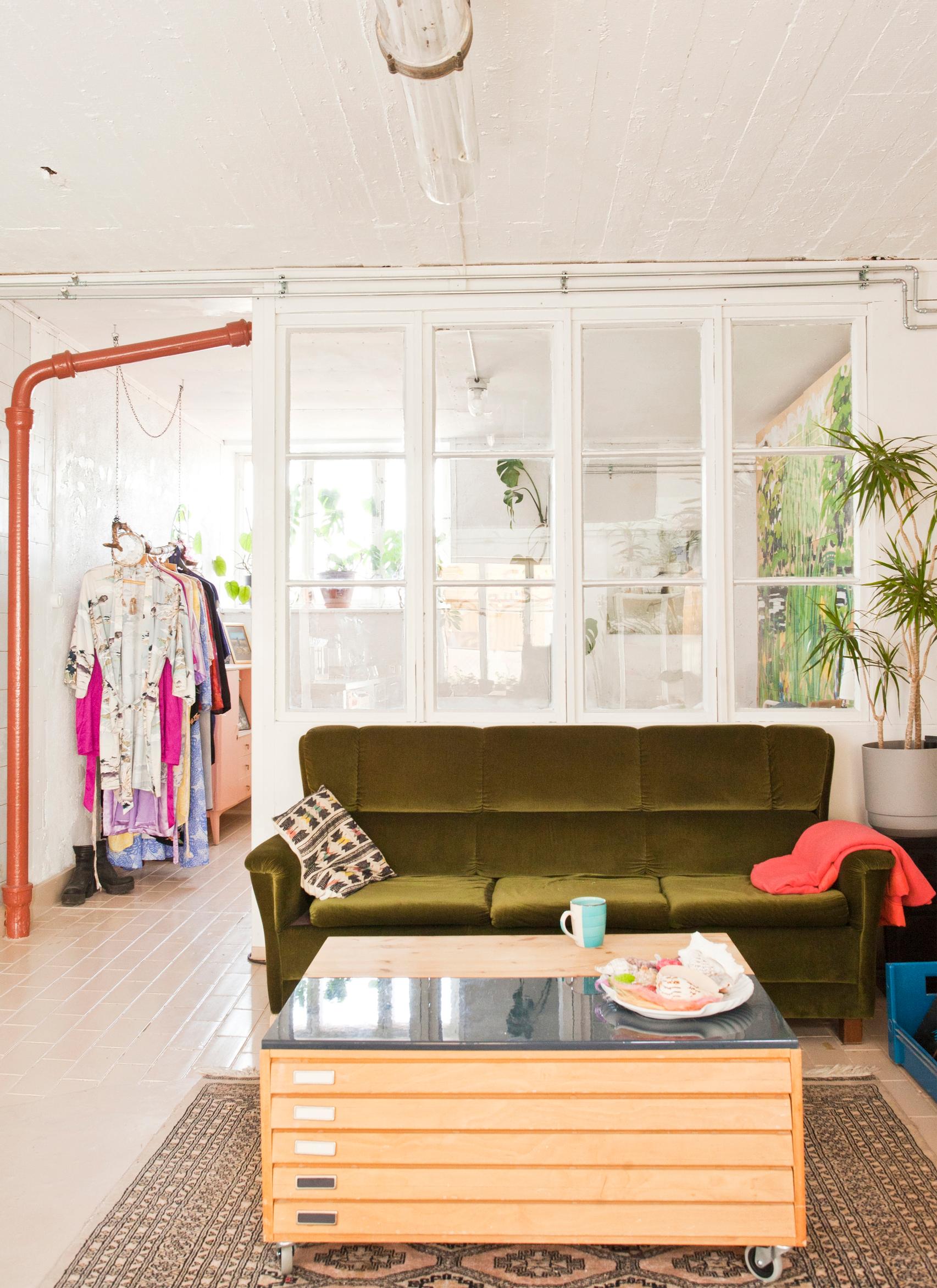 Green velvet sofa and a partition wall made of old windows