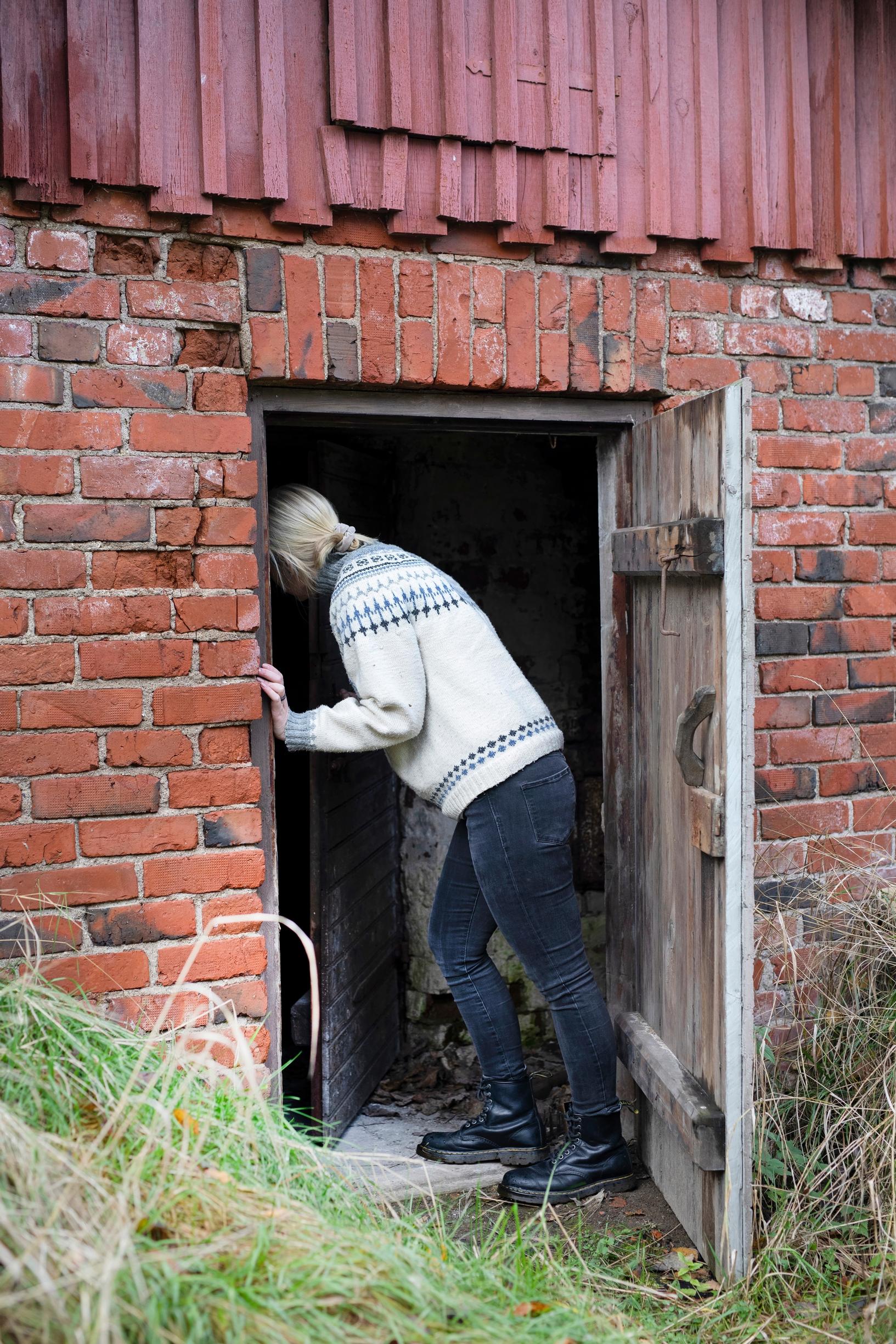 woman collecting firewood from a shed