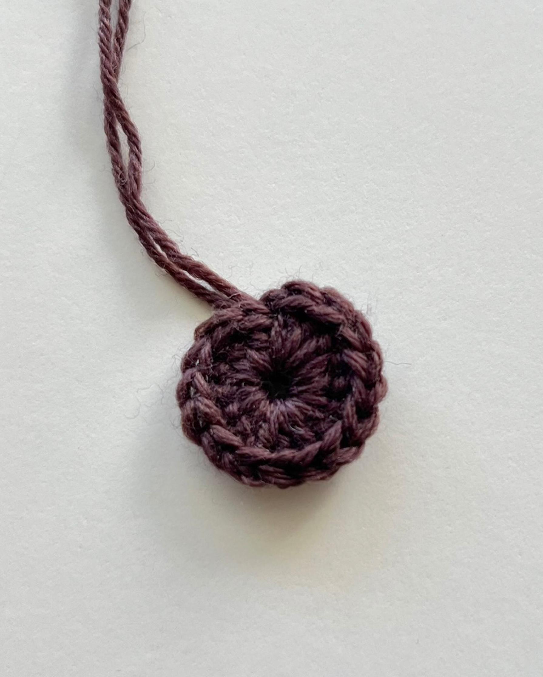 Sunflower granny square round 1 in dark brown yarn