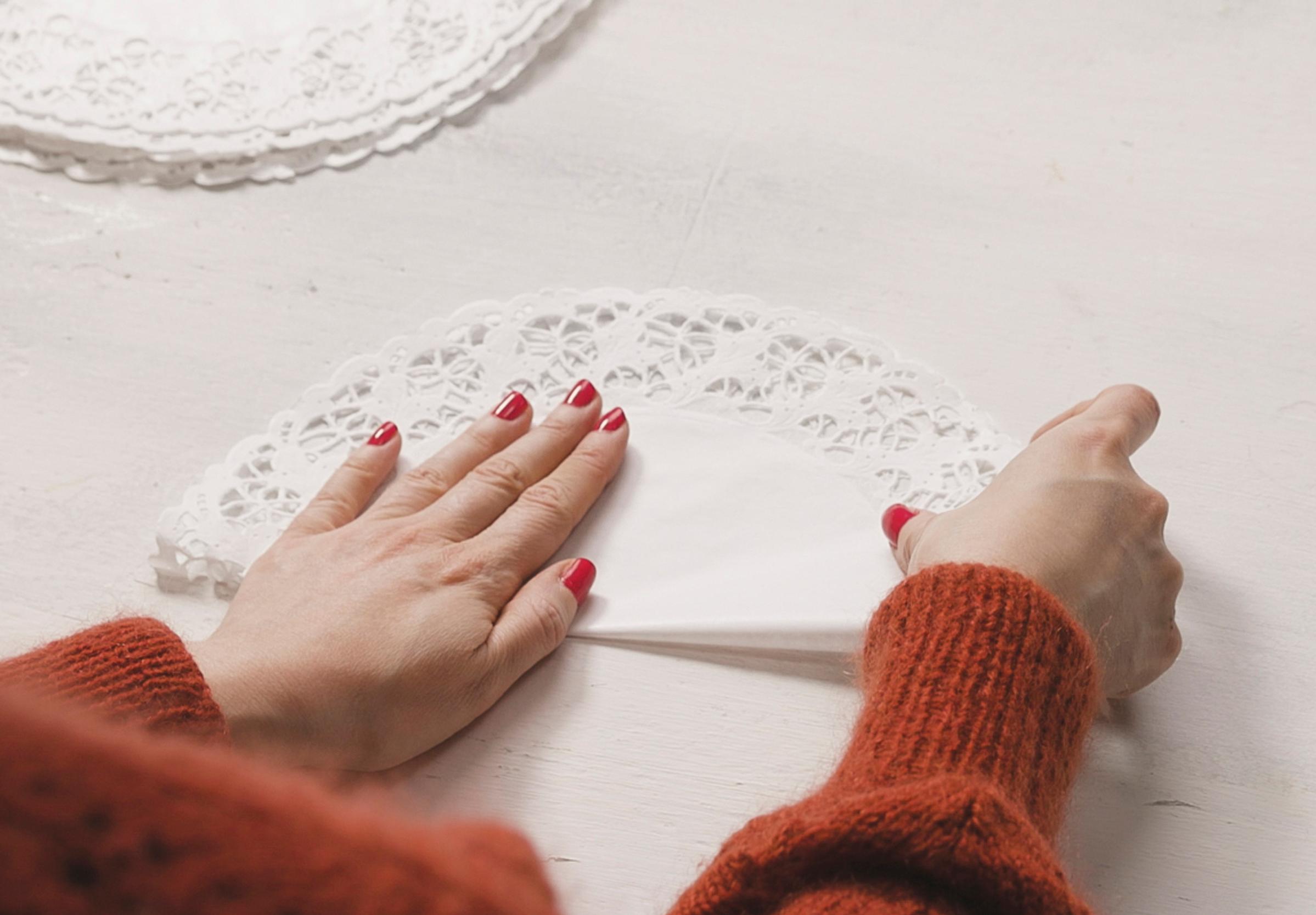 Folding the paper doily in half