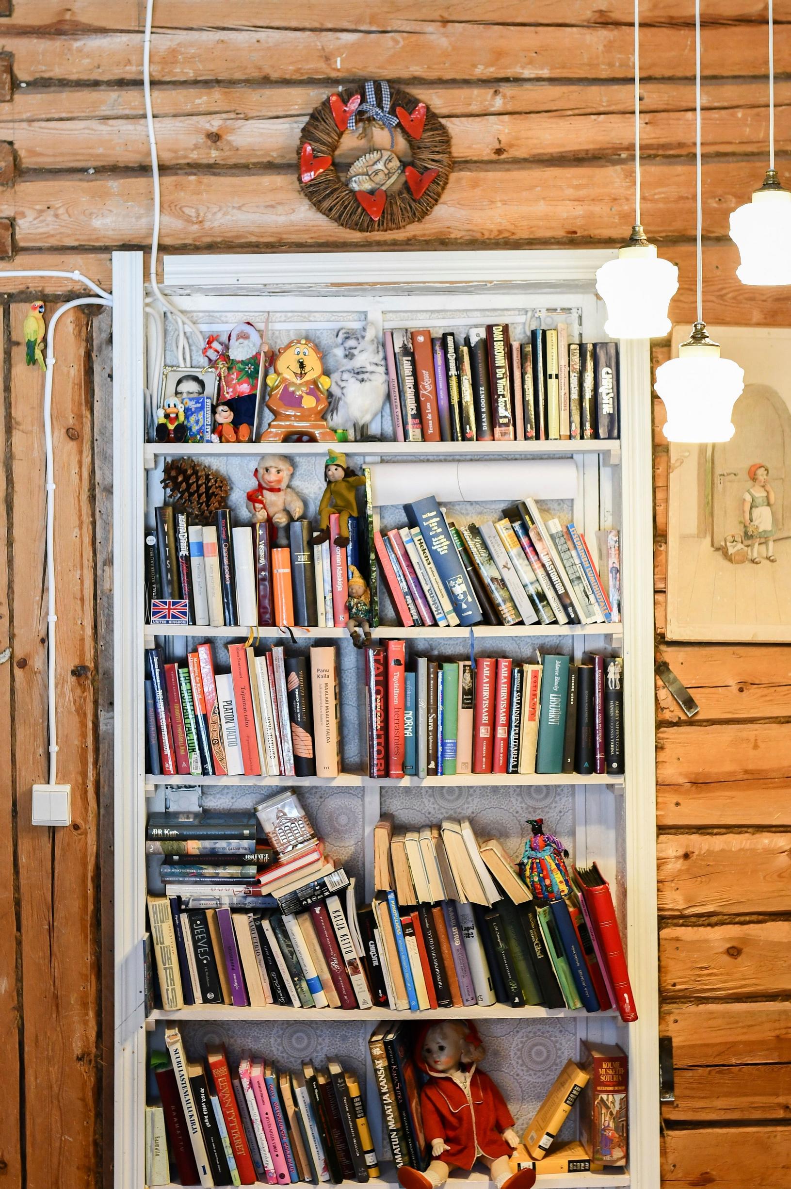 A bookshelf against a log wall.