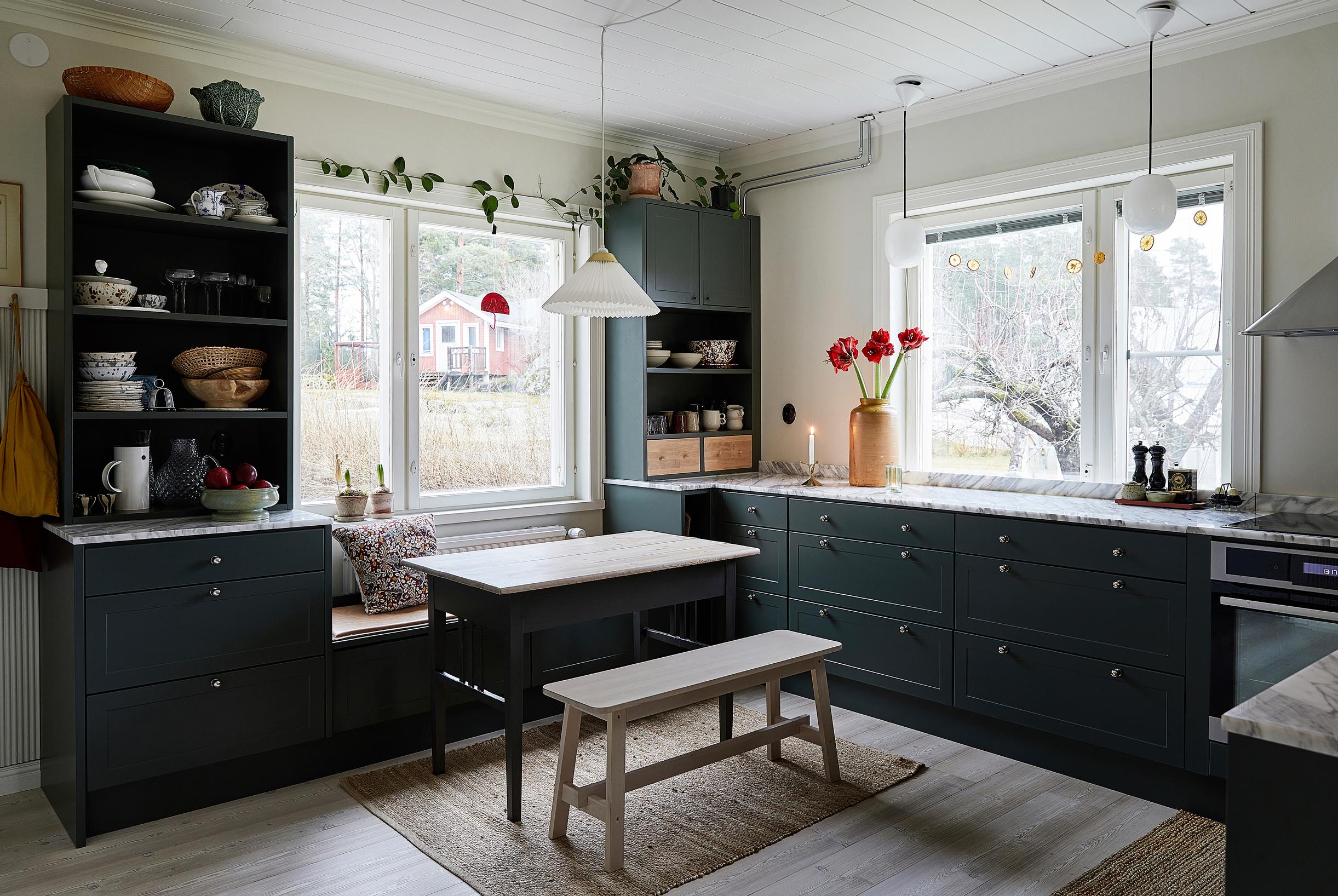 A dark green kitchen and dining area