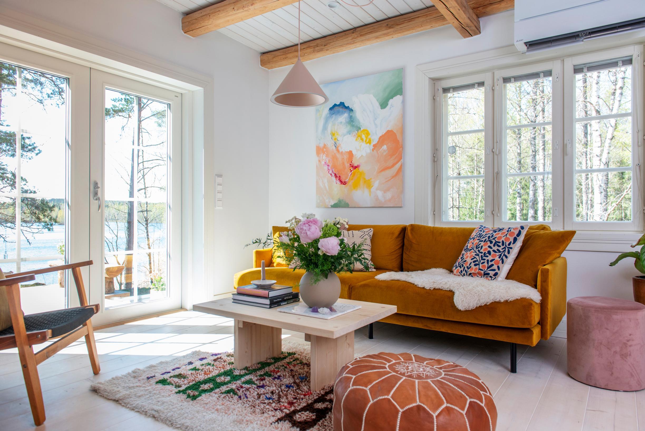 A bright living room with colorful textiles and lake views