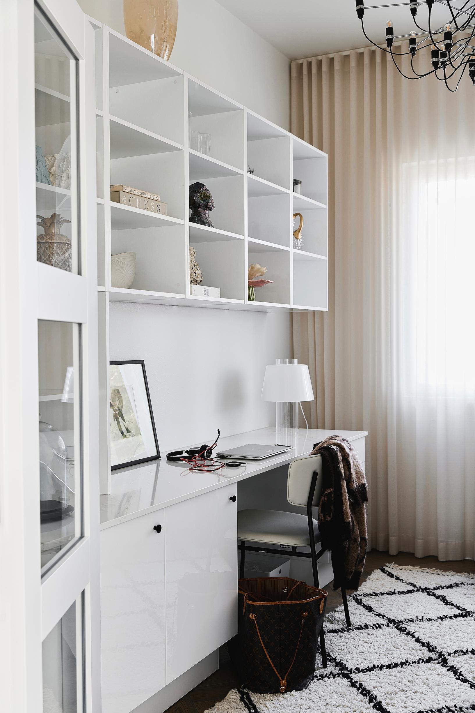 A workspace with white built-in cabinets.