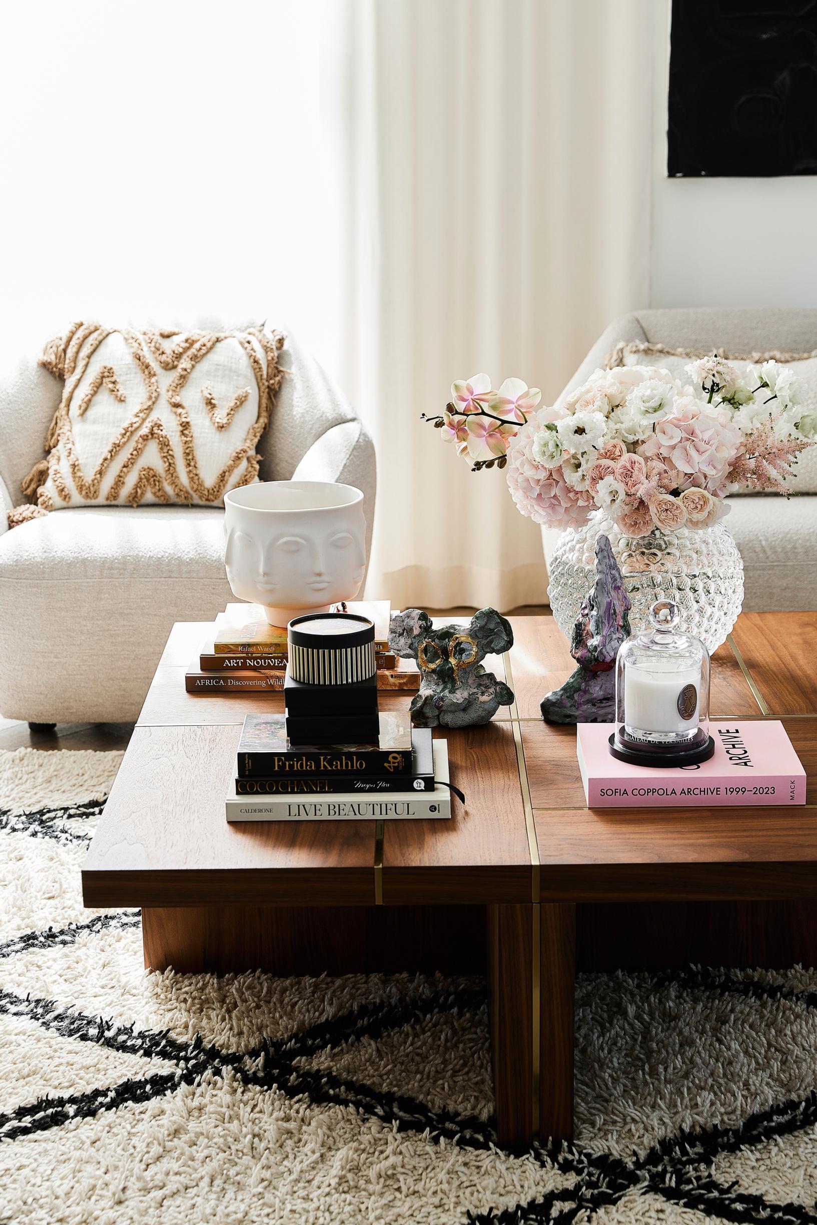 A low coffee table with books and art objects on top.