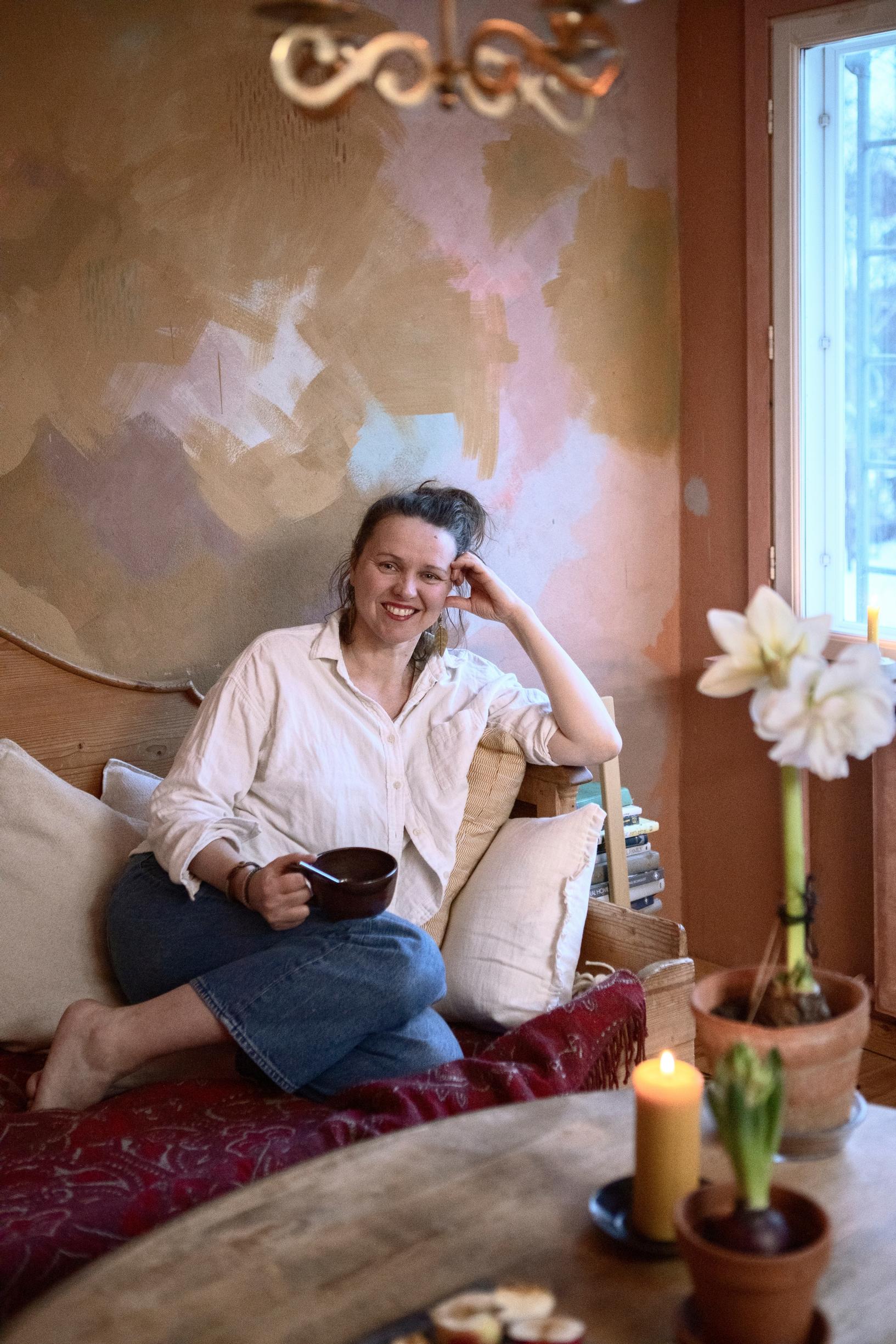 Suveka Kymäläinen sits on the sofa